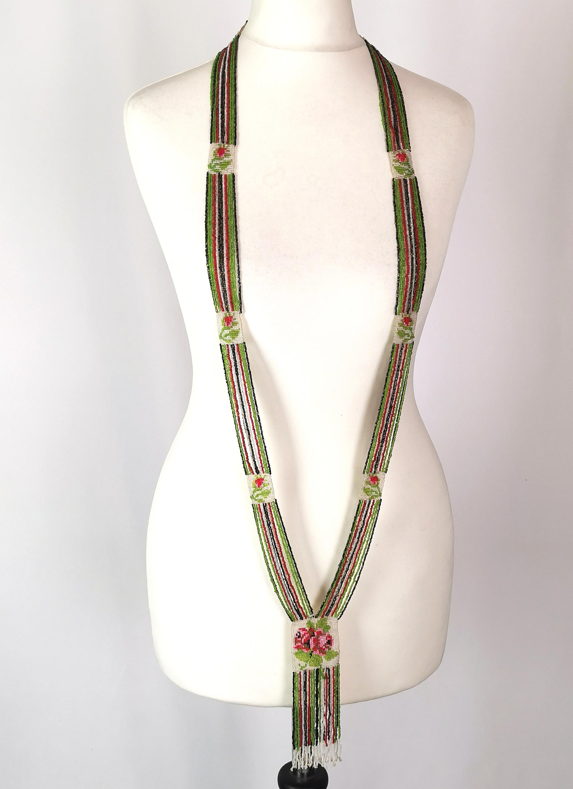 A rare Vintage Art Deco glass beadwork sautoir necklace.

This is a long, Flapper length necklace, constructed from rows and rows of tiny, hand strung glass beads in green, pink, black and white.

The necklace has small beadwork panels at intervals