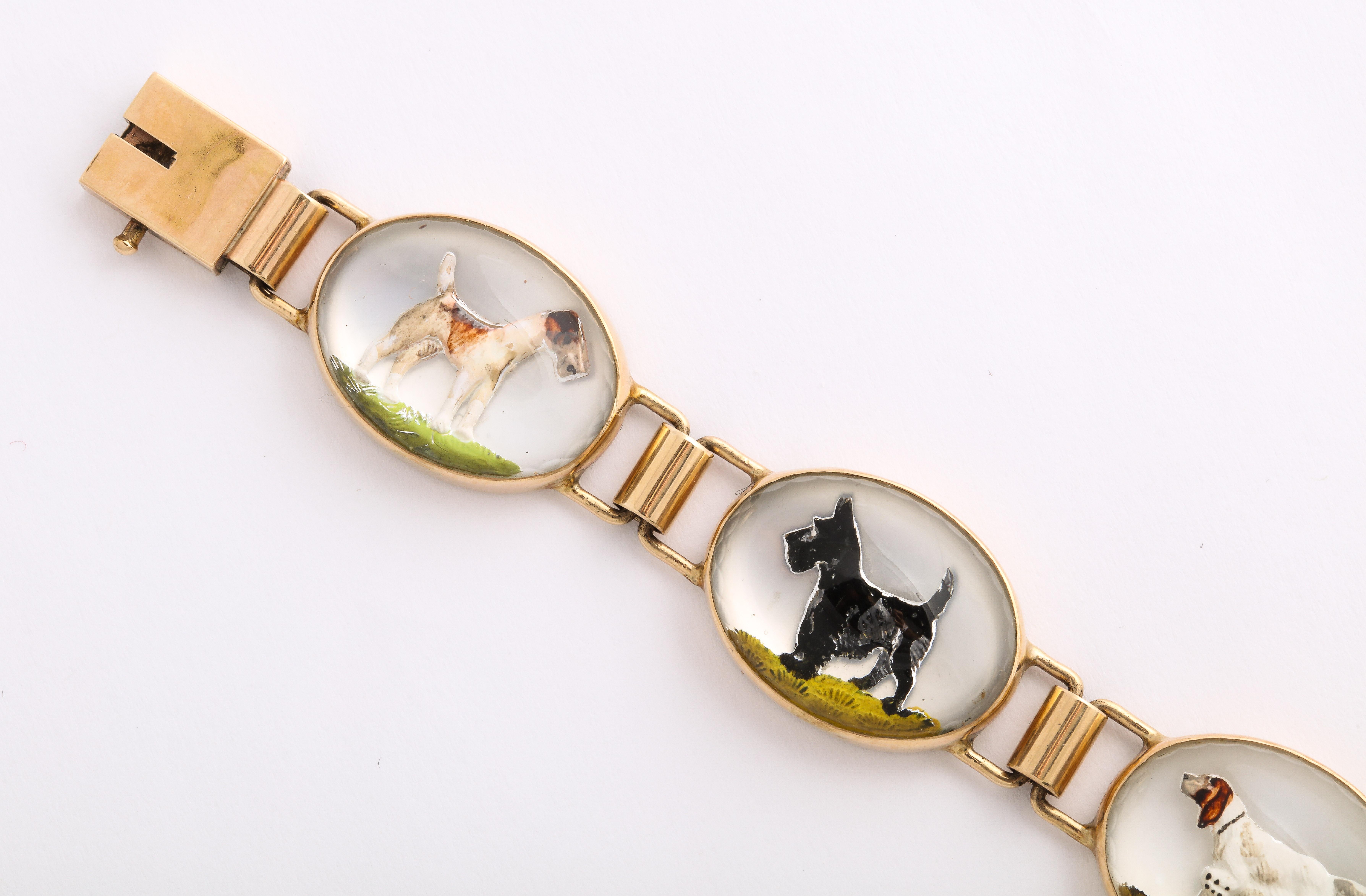 Oval links of 14 Kt gold and rock crystal hold cuddly Scottie Dogs, Terriers and Hounds their images carved and transfixed on a mother of pearl background, The bracelet is a whimsical conversation piece made c. 1930 in the United States. I have not
