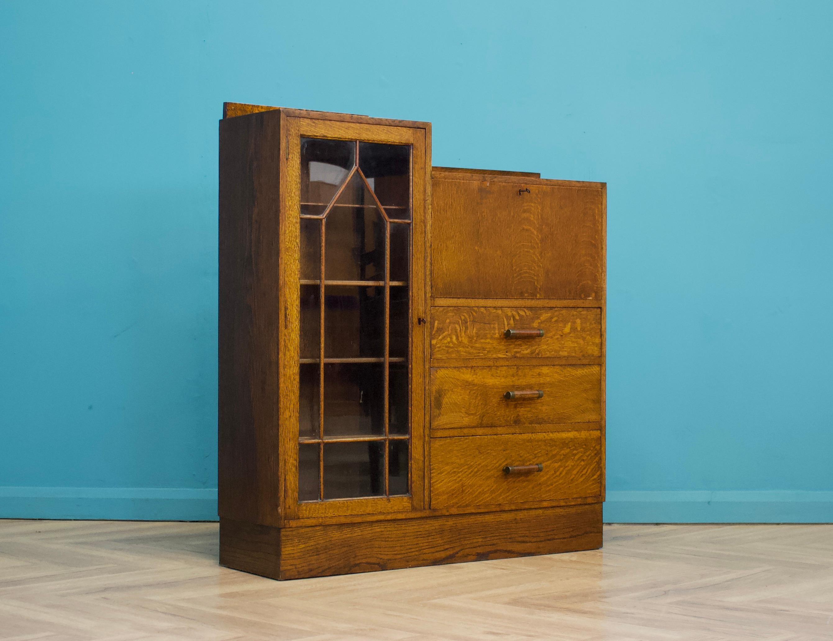 Eine schöne Qualität, 1930's Eiche bureau Bücherregal, in der Art von Heals
Auf der einen Seite befindet sich ein Bücherregal mit Bleiglastüren, auf der anderen ein ausziehbarer Schreibtisch mit Fächern und Schubladen.