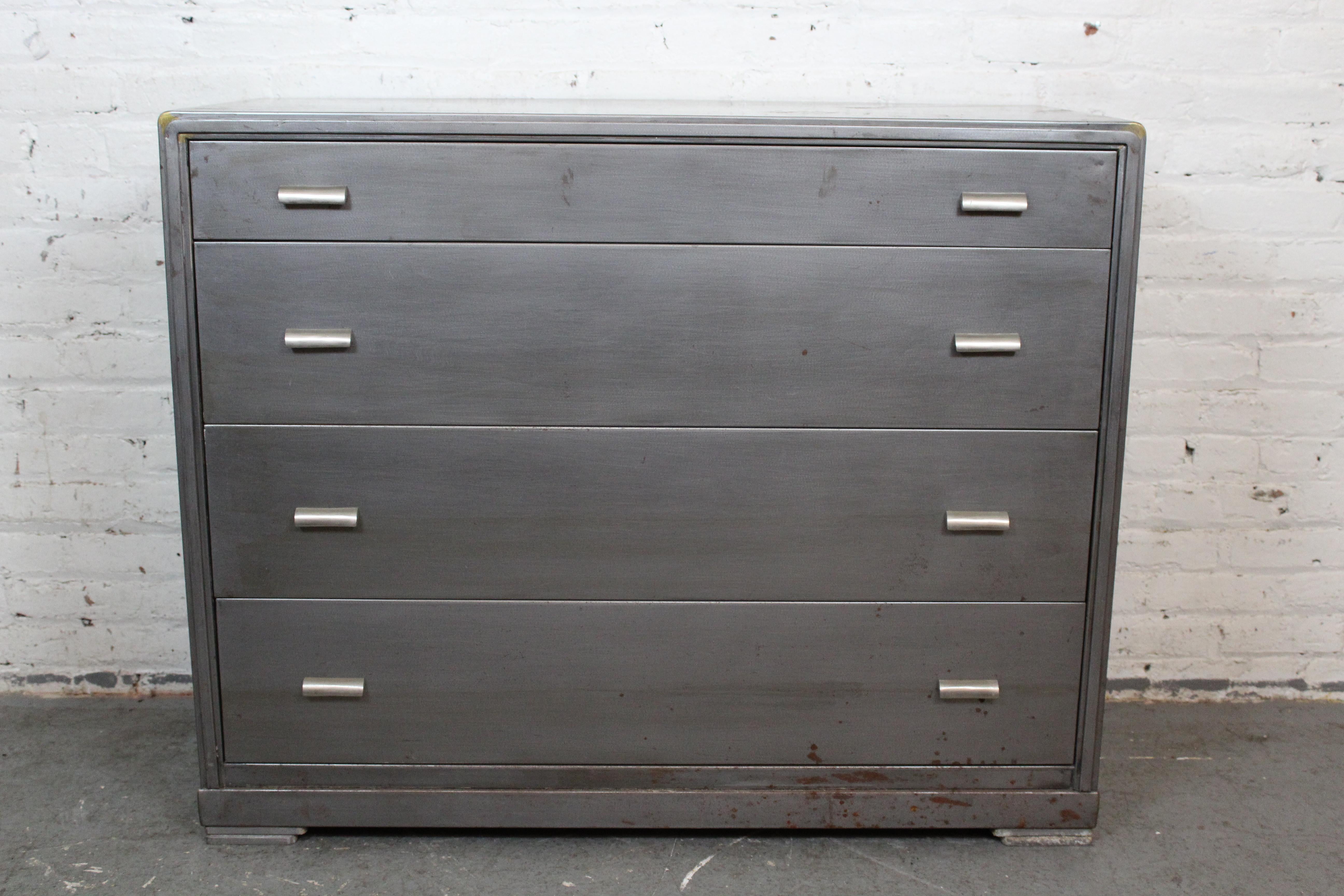 Aprovecha la genuina artesanía de la era industrial estadounidense con esta robusta cómoda de acero fabricada por la Simmons Company Furniture de Chicago. Esta robusta y achaparrada maleta dispone de cuatro amplios cajones extraíbles, perfectos para