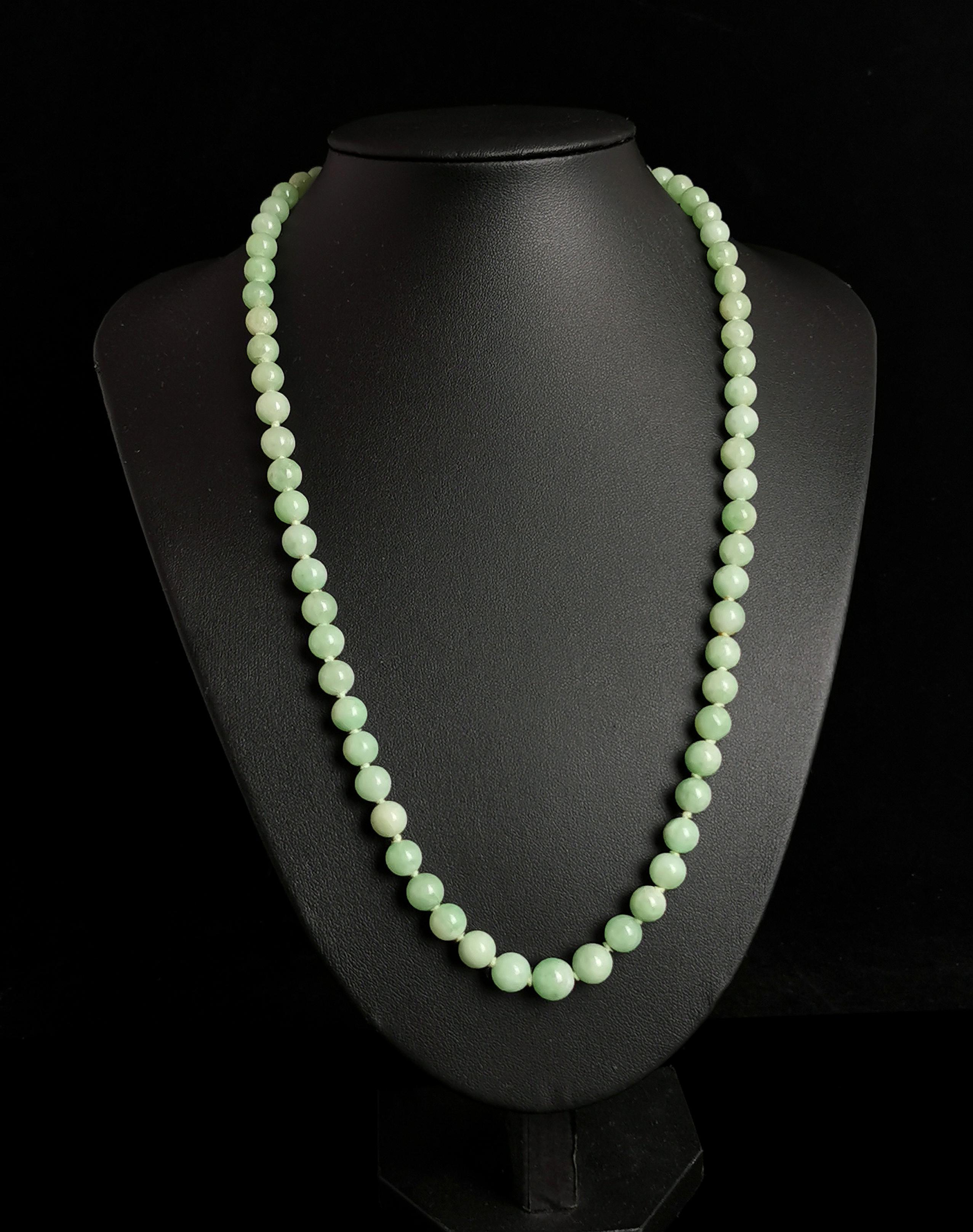 A beautiful vintage Art Deco era Jadeite Jade bead necklace.

Lovely apple green beads, with beautiful variations in the colourway from almost white to darker streaks, all delicately hand shaped and tightly knotted onto a cotton thread.

The beads