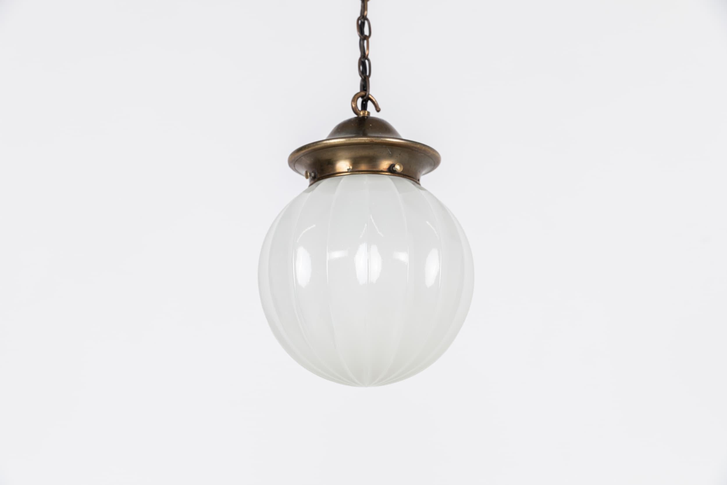 

An elegantly formed spheprical opaline pendant lamp. c.1930

Thick pressed glass with ribbed design. Faintly stamped 'Jefferson' to the rim. Complementing and period brass gallery.

Rewired with 1m black twisted flex.
