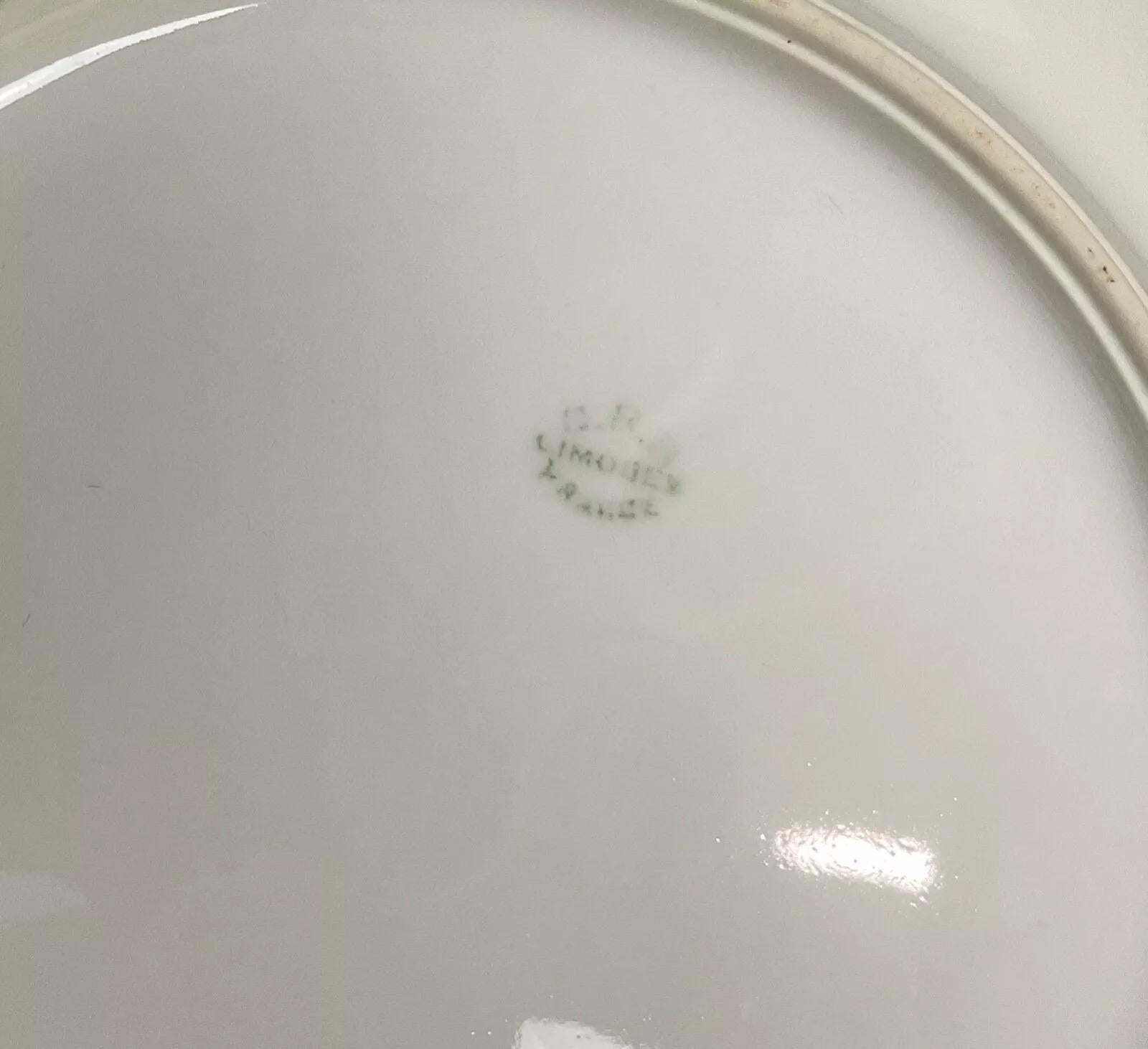 Diese flache Schale im Art-déco-Stil von D.R.B. aus Limoges ist eine elegante Ergänzung für jeden gedeckten Tisch und jede Sammlung. Mit einem Durchmesser von 28 cm (11 Inches) und einer Höhe von 6 cm (2.4 Inches) wiegt diese schöne Porzellanschale