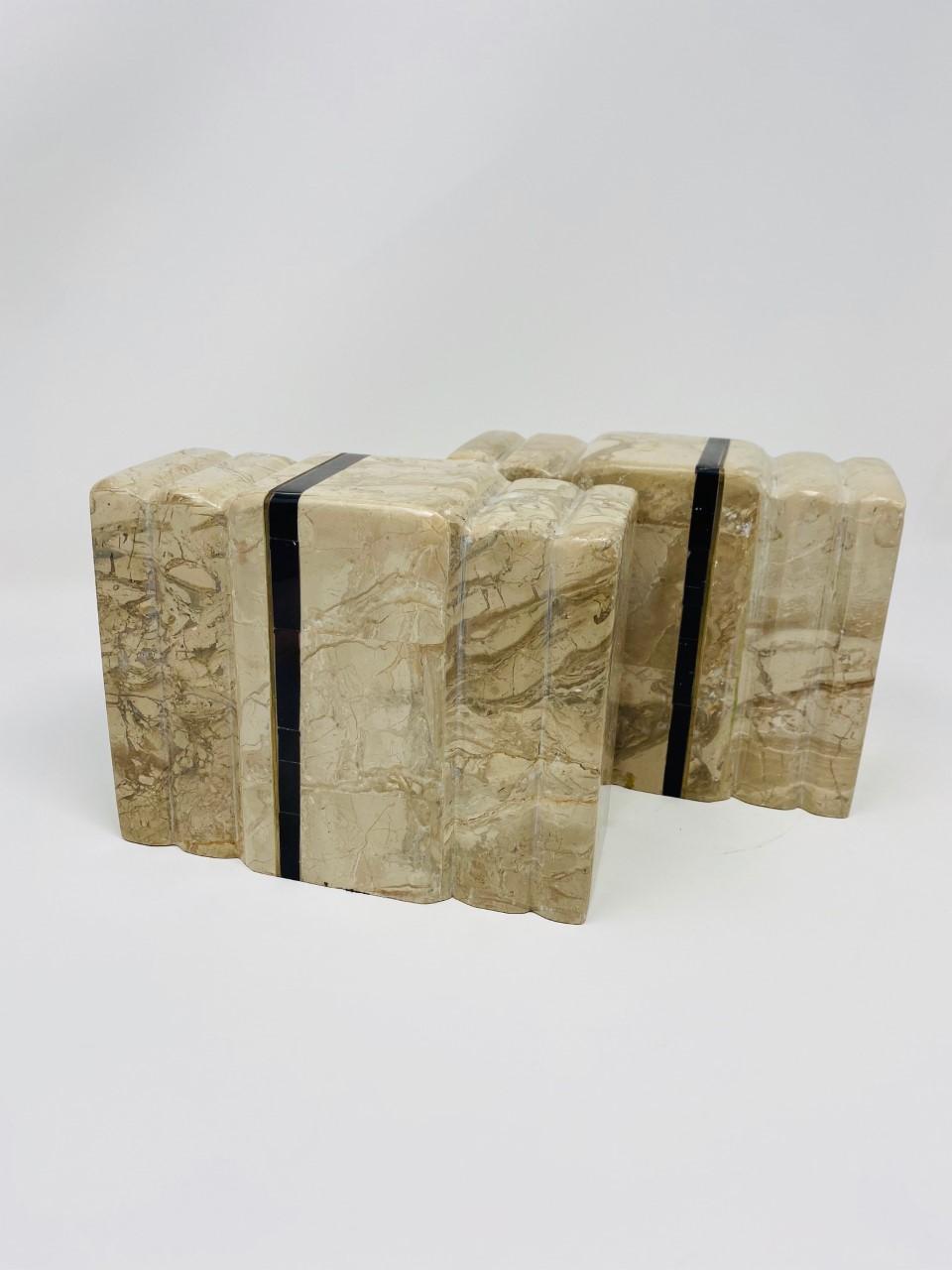 Beautiful pair of art deco marble bookends by Renoir. These sizeable pieces of marble are captivating as they are commanding. The veining that develops on the beige marble with pink undertones ondulates as the shape forms columns that melt together.