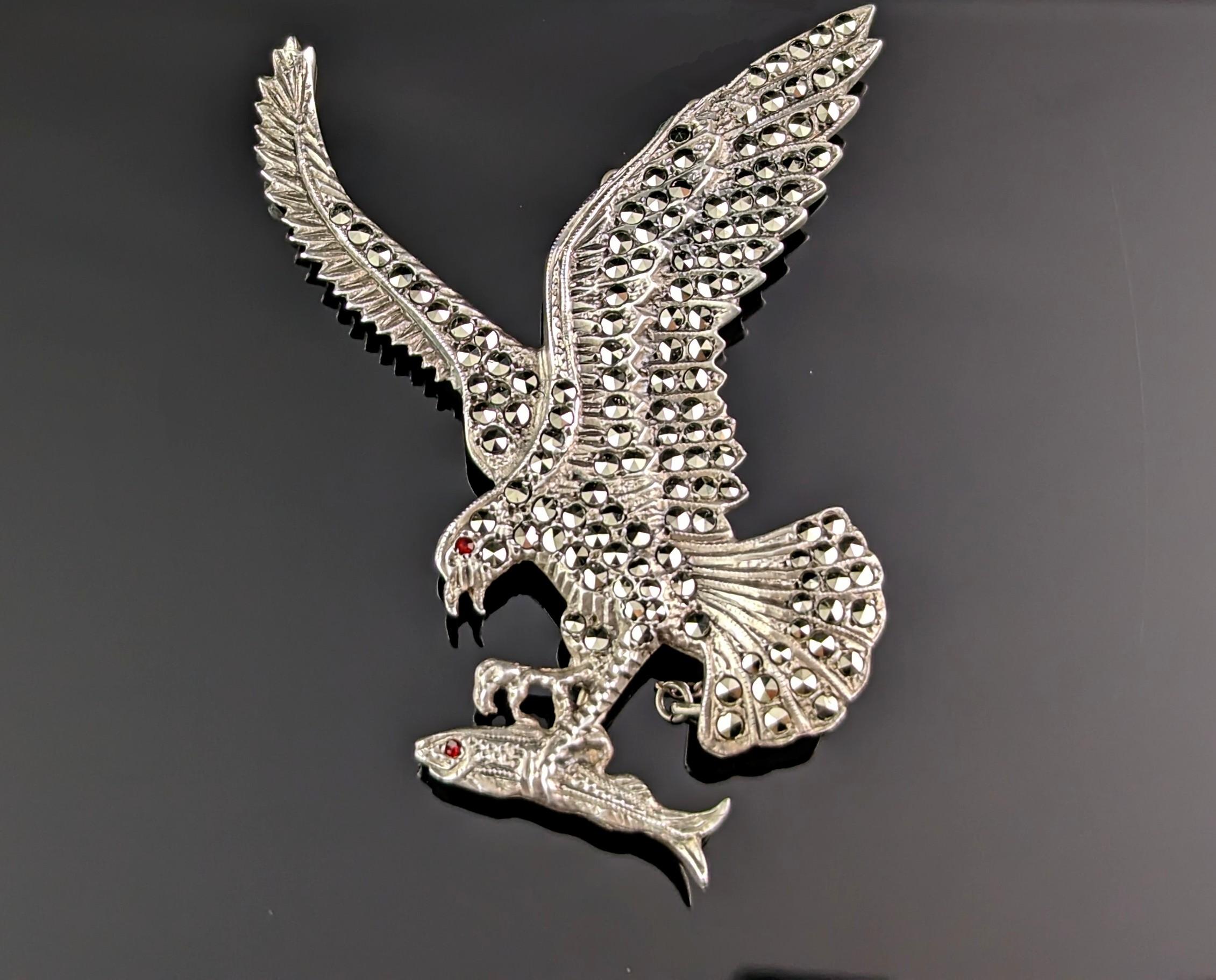 A charming Art Deco era c1930s silver and marcasite eagle brooch.

This is a large brooch well modelled as an eagle grasping a fish in sterling silver, adorned with marcasite and each animal has a tiny red paste eye.

Such a gorgeous vintage brooch,