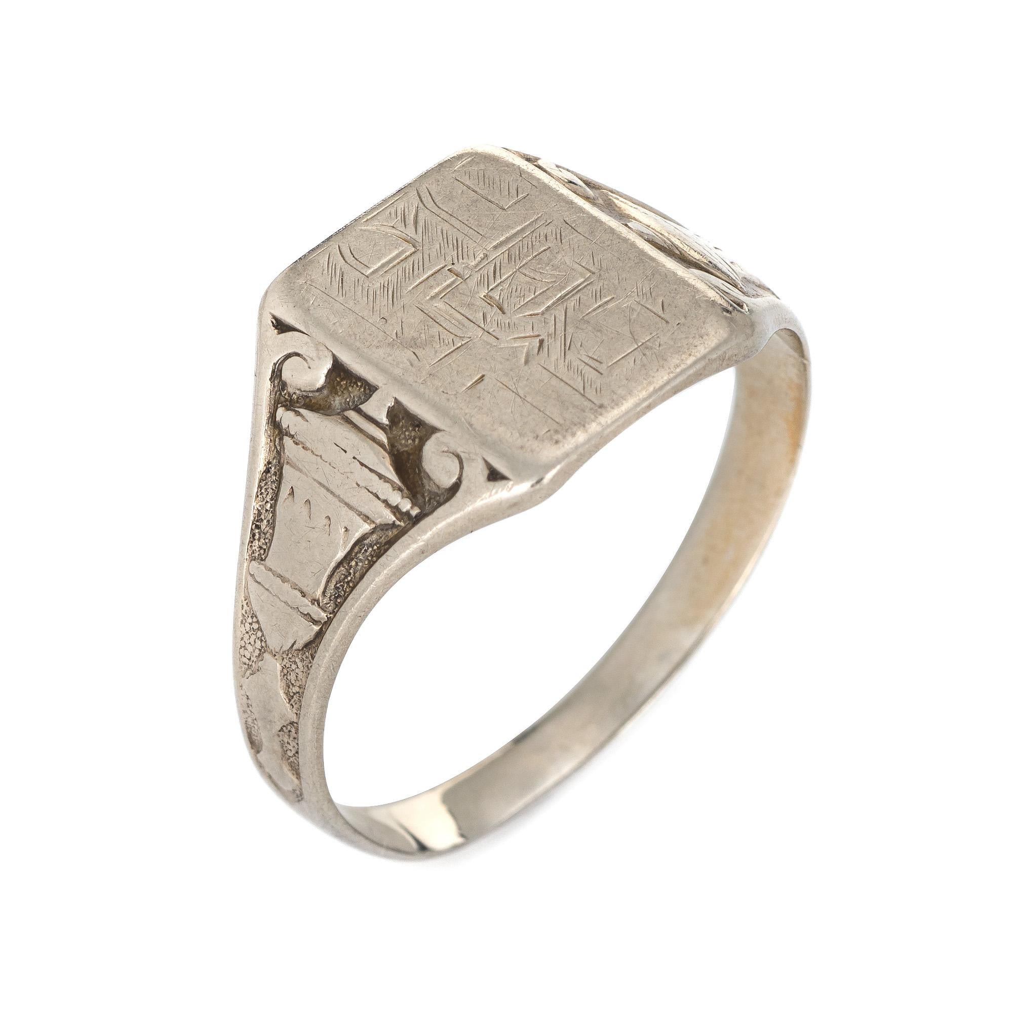 Finely detailed vintage Art Deco era signet ring (circa 1920s to 1930s) crafted in 14 karat white gold. 

The signet ring features a square mount (with an engraving) yet unfortunately due to wear we are unable to decipher the letters. The side
