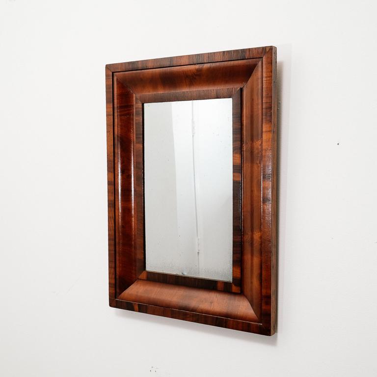 Vintage Modernist mirror with Art Deco design cues. Beautiful stained veneer frame with original glass.