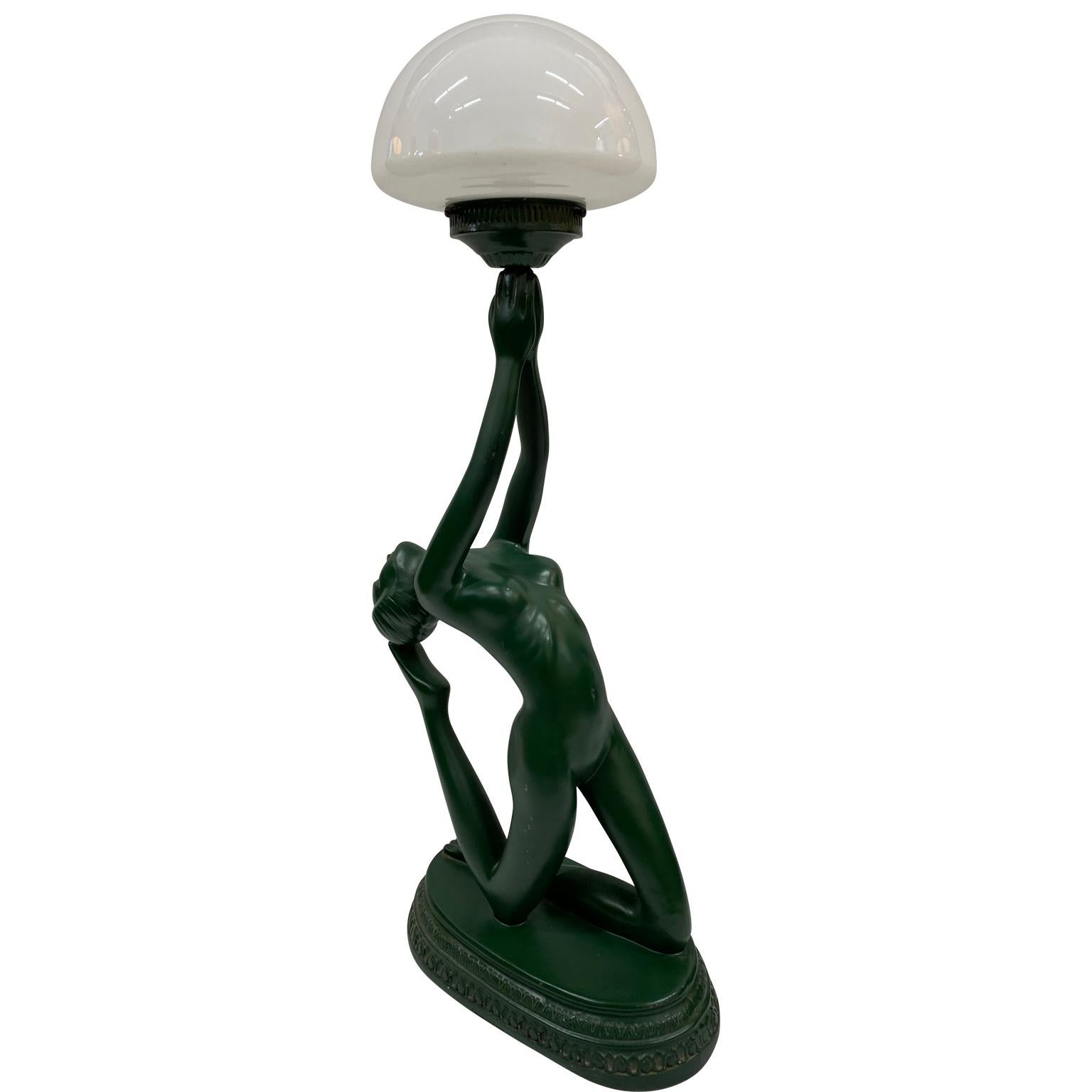 This lovely nude ladt amp is a very sturdy and well made lamp. The lamp is dark green; made of heavy resin, having a very smooth matte finish. The woman is holding a frosted glass globe that provides great accent and ambient mood light. The light