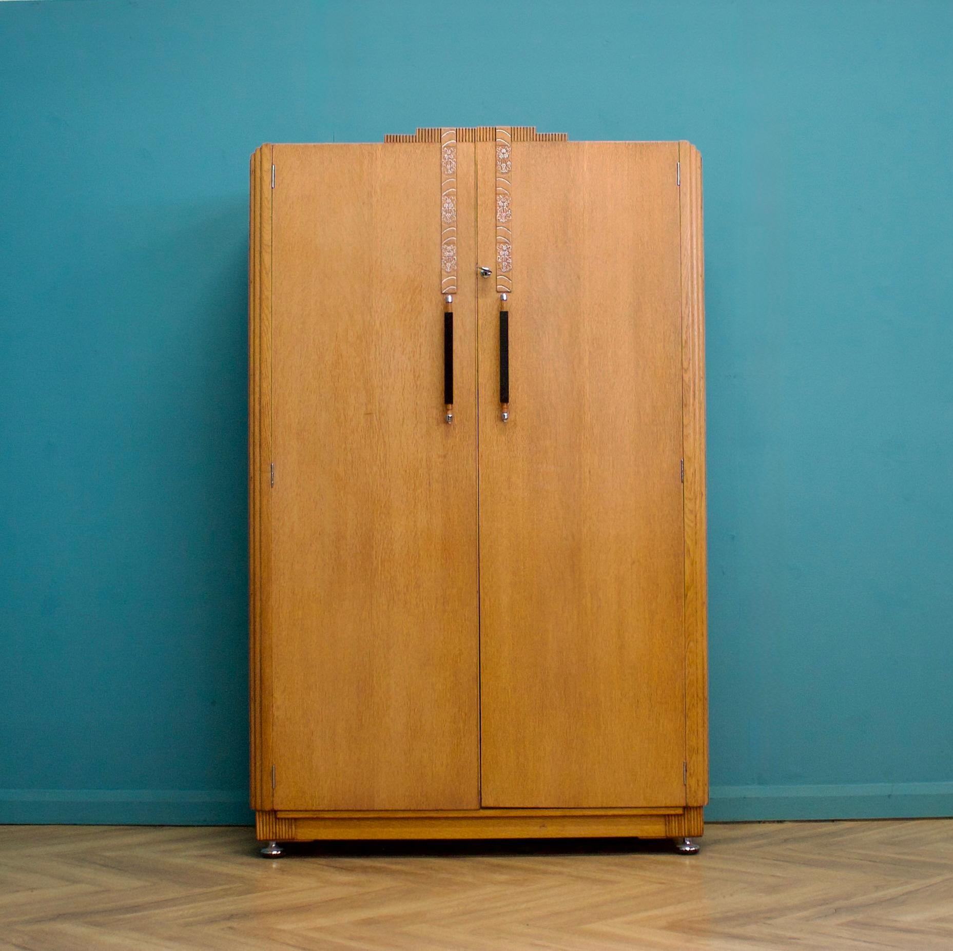 This quality vintage oak wardrobe from G Plan (E Gomme) is circa 1930s.


Inside, it is beautifully fitted out with two pull-out rails, a drawer, and shelves. It also features the original key with E Gomme factory embossed on it.


The matching