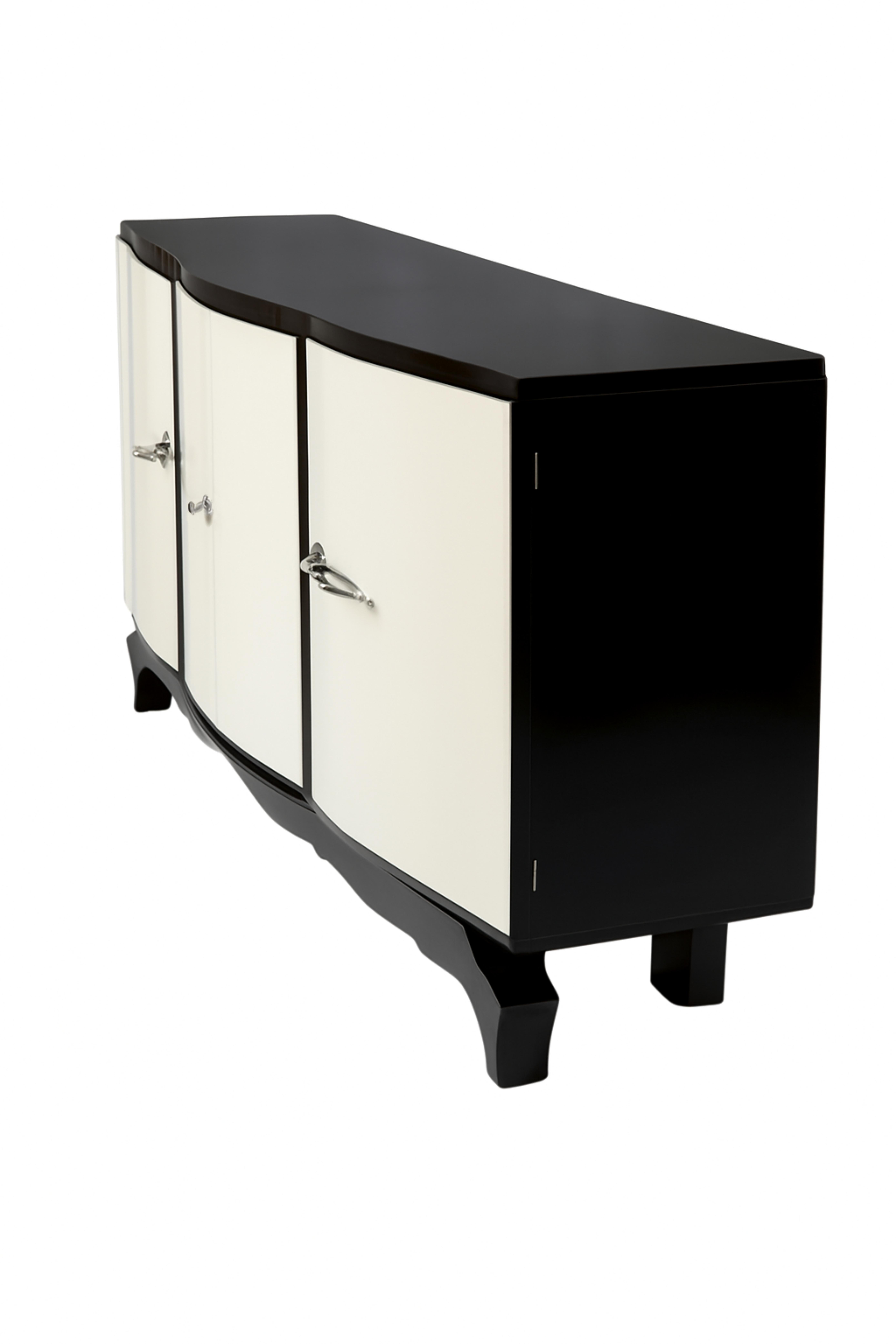 Questa splendida credenza Art Deco, realizzata negli anni '30, incarna l'eleganza e la raffinatezza dell'epoca. Whiting tra l'influenza americana e il fascino francese, il pezzo è caratterizzato da maniglie e ferramenta cromate che brillano sulla