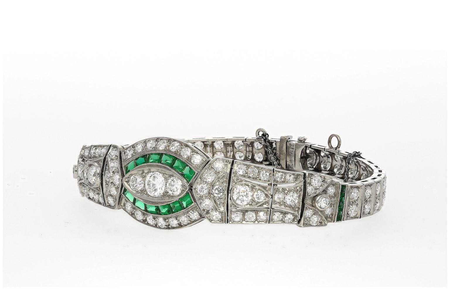 Original vintage/antique Art Deco era diamond and emerald bracelet Set with a 1 carat center stone, encrusted by 119 old-cut diamond accents and a beautifully tension-set halo of 18 baguette-cut emeralds. Handmade by expert jewelers almost 100 years