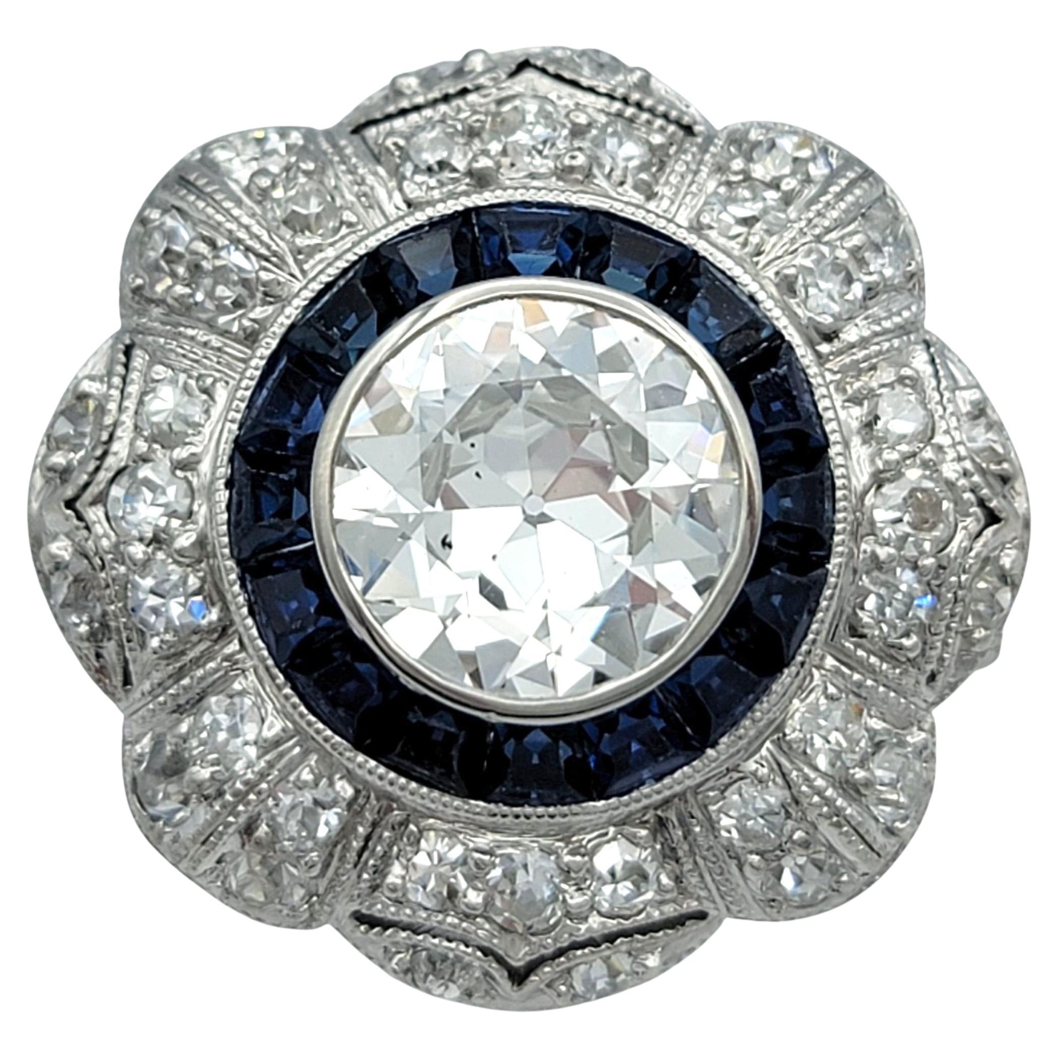 Ring Größe: 6.5

Dieser atemberaubende Vintage-Ring strahlt zeitlose Schönheit aus. Sein Diamant im Old-European-Schliff ist von einem Halo aus blauen Saphiren im Rechteckschliff umgeben. Die Fassung ist aus hochwertigem Platin gefertigt und