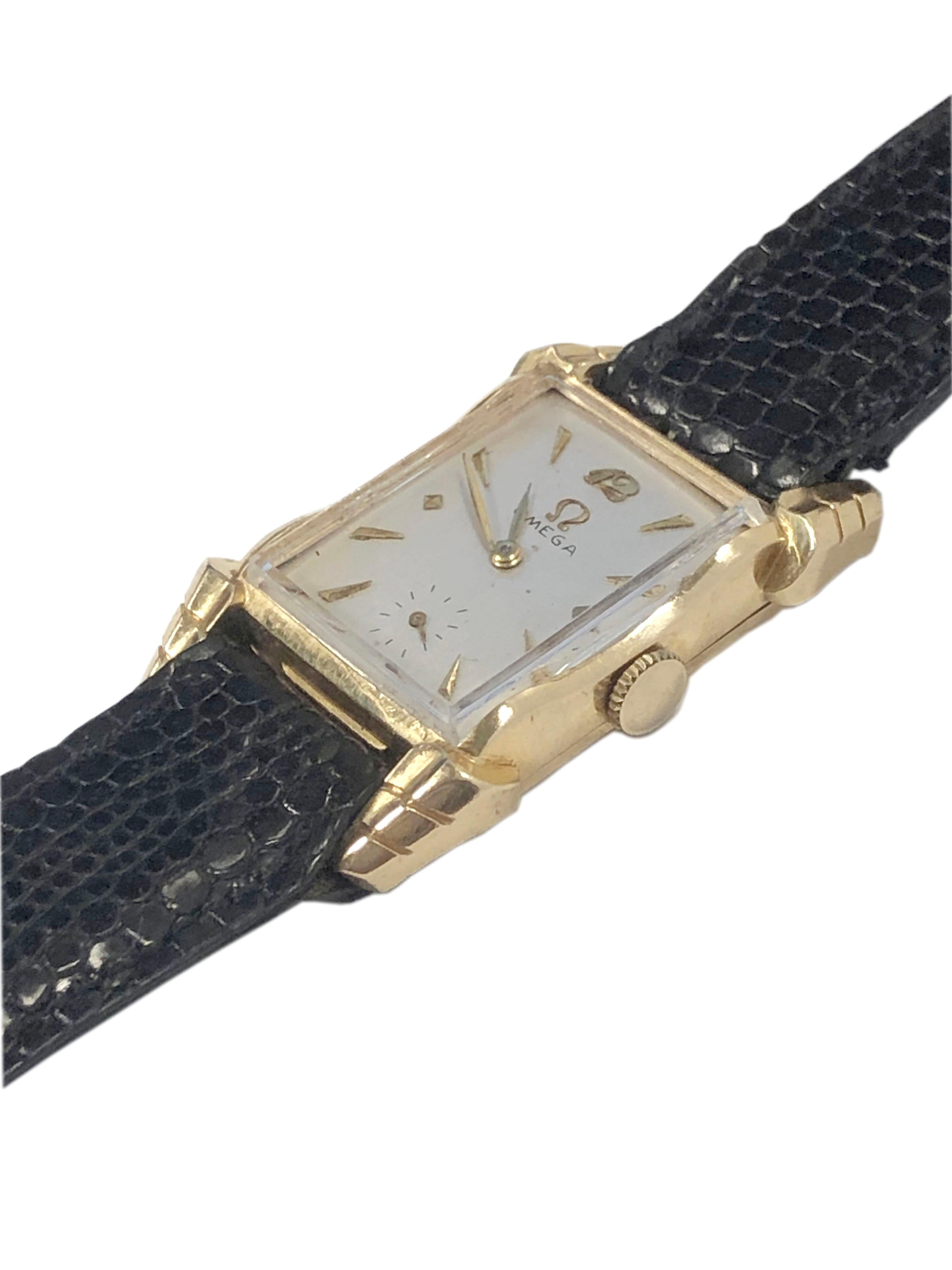 Circa 1940 Omega Wrist Watch, 39 X 21 M.M. 2 Piece 14k Yellow Gold Omega signed case with fancy flared Lugs. 17 Jewel Mechanical, Manual wind movement. Silver Satin dial with raised gold markers. Black Lizard Strap.