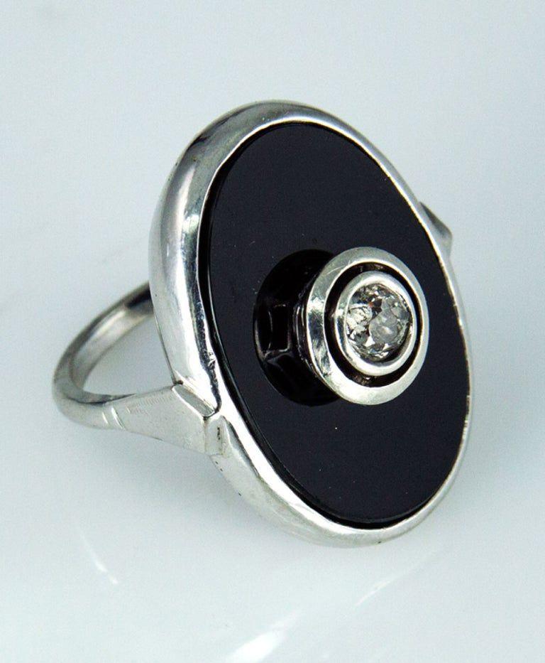 Tout simplement magnifique ! Classique et intemporelle, cette bague Runway Ring présente les caractéristiques de la célèbre période Art déco. L'onyx noir ovale est centré sur un diamant de taille européenne ancienne, pesant environ 0,45 carat, en