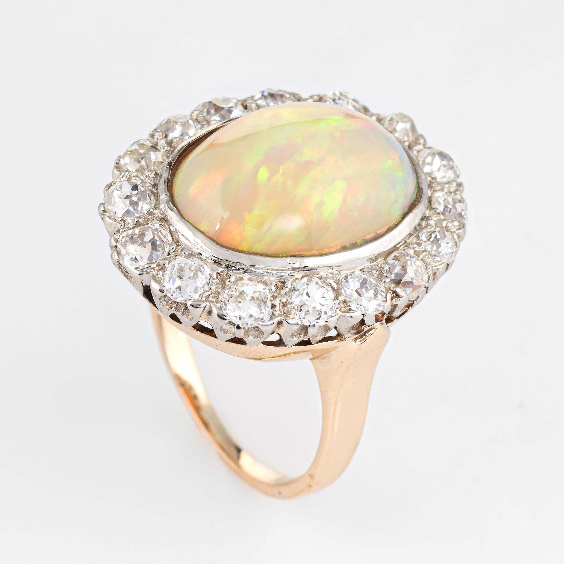 Striking vintage opal & diamond ring (circa 1920s to 1930s), crafted in 14 karat yellow gold. 

Centrally mounted natural opal measures 14mm x 11mm (estimated at 6 carats), accented with 16 estimated 0.10 carat old mine cut diamonds. The total