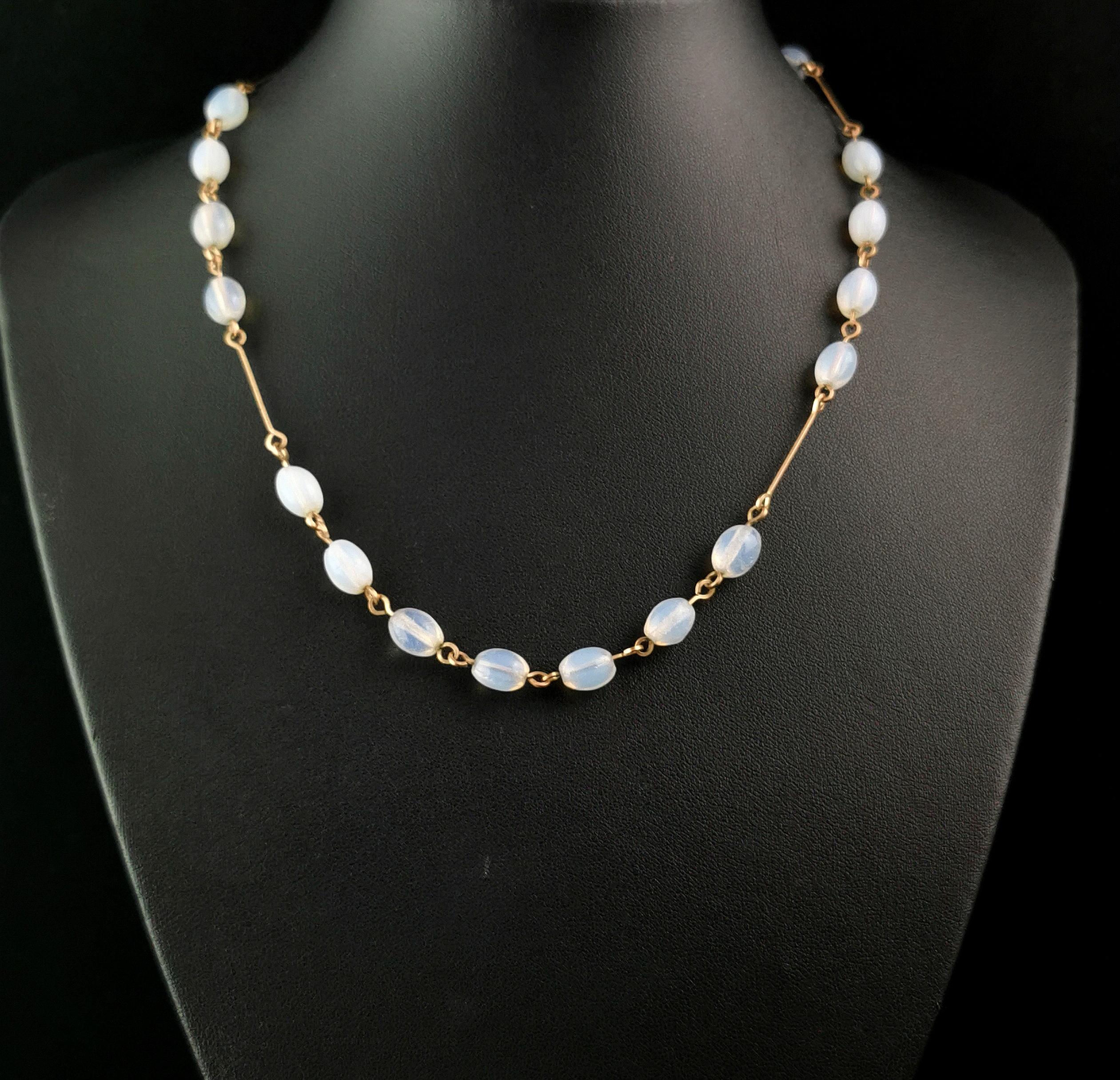 A gorgeous vintage Art Deco opaline glass bead necklace.

It is made up from oval shaped opaline glass beads, slightly opaque with a mostly blue hue.

The beads are affixed to a gold plated chain necklace with a hook fastener.

An elegant and