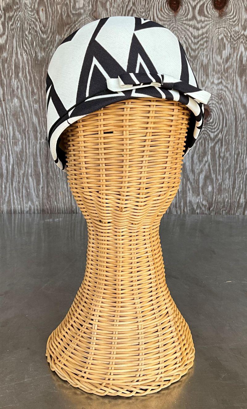 Un cappello vintage Art Déco Pillbox combina i principi del design geometrico ed elegante del movimento Art Déco (che fiorì negli anni '20 e '30) con la classica forma del portapillole. L'Art Déco è nota per le sue forme slanciate e filanti, per le