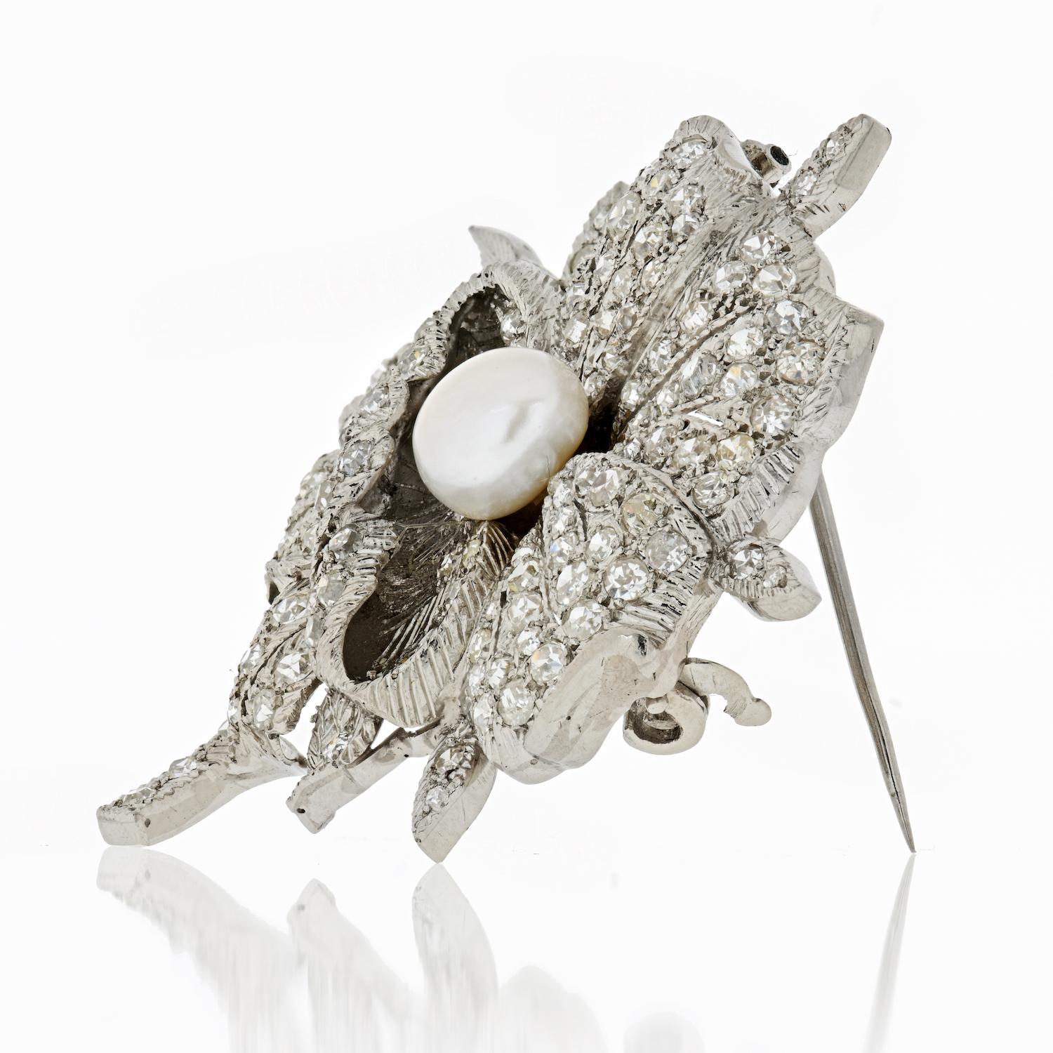 This fine Art Deco brooch features a natural off white pearl and amid beautifully decorated old single-cut diamond petals. The brooch invokes the look of a beautiful flower with its pearls creating a lovely glow among the old single-cuts encrusted