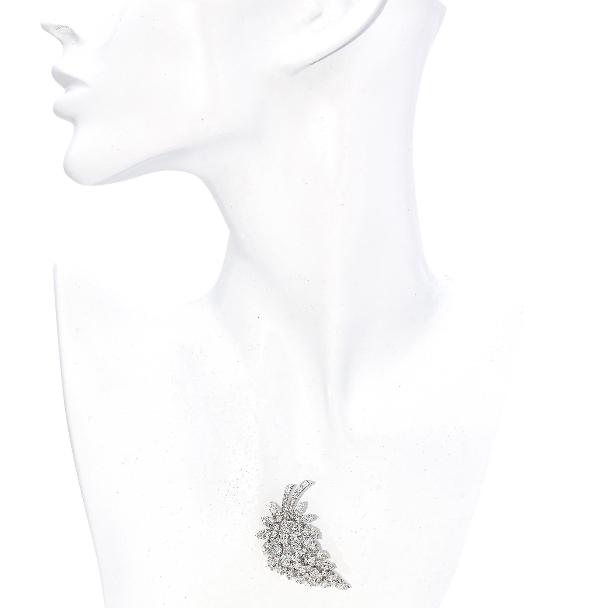 Este impresionante y elegante broche es una auténtica obra maestra, con un diseño en cascada que combina el brillo de los diamantes redondos y baguette. Los diamantes están dispuestos meticulosamente para formar un elegante motivo floral, con cada