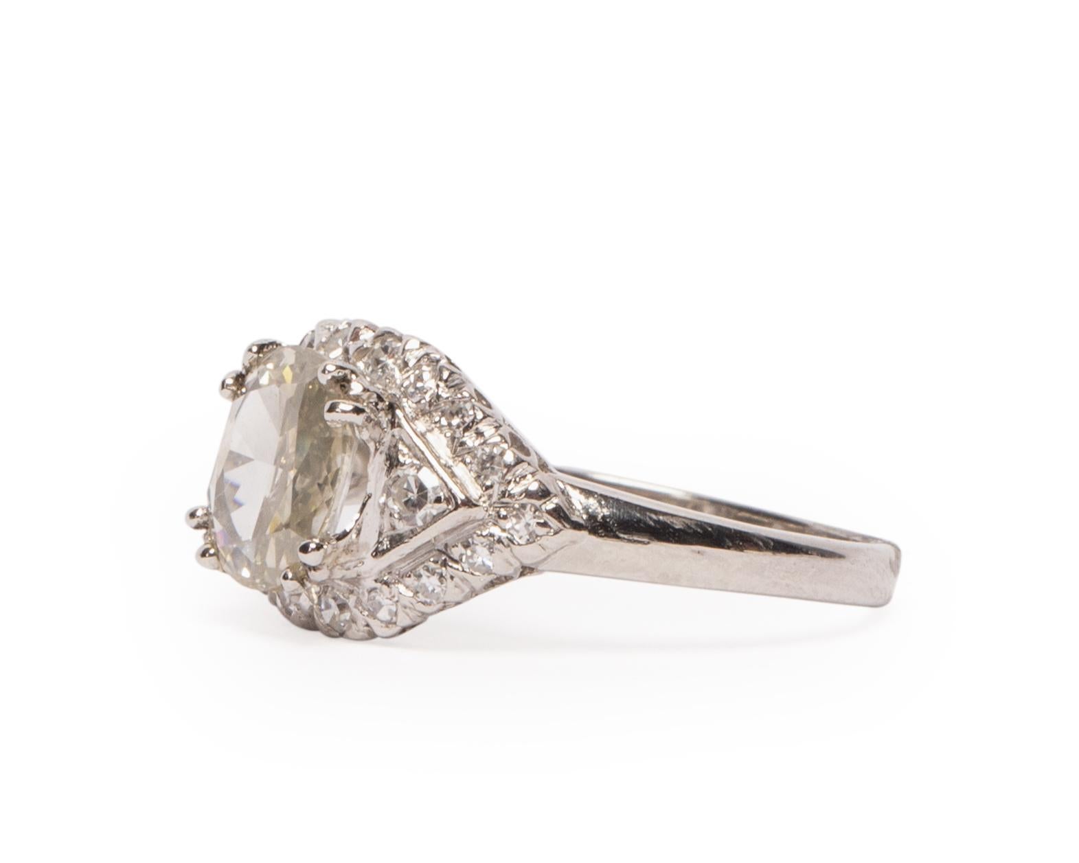 This 1920's beauty is a great example of the Art Deco era. A elegant rose cut diamond accented by two diamonds on either side, surrounded by even more beautiful eye clear diamonds, who doesn't love a little extra sparkle. The platinum ring has stood