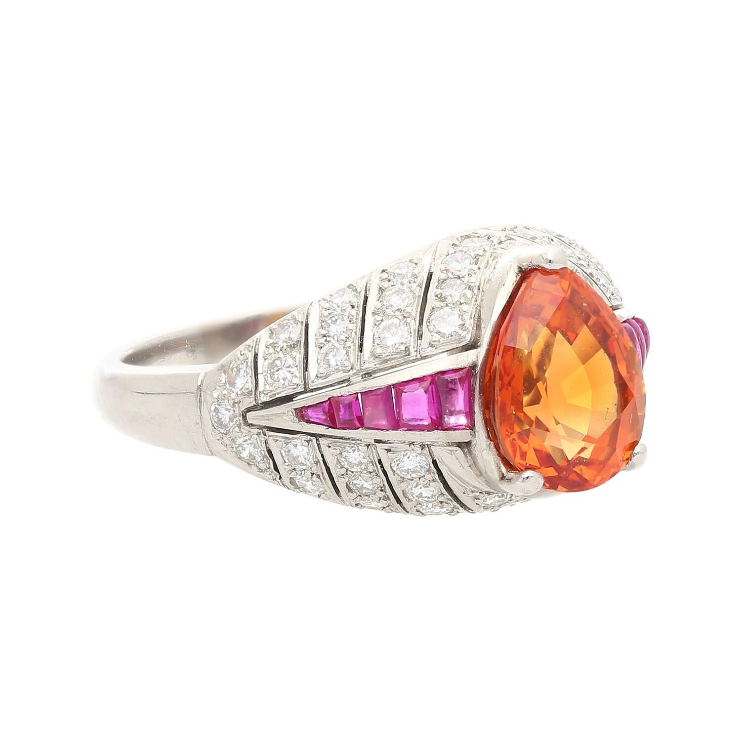 Introducing a vintage Art Deco era ring setting, repurposed with a 2.87 carat pear cut Orange Sapphire. Set with 52 round cut diamonds and 10 baguette cut rubies. Set in platinum. 

A gorgeous cocktail ring with historic origins. A beautiful blend