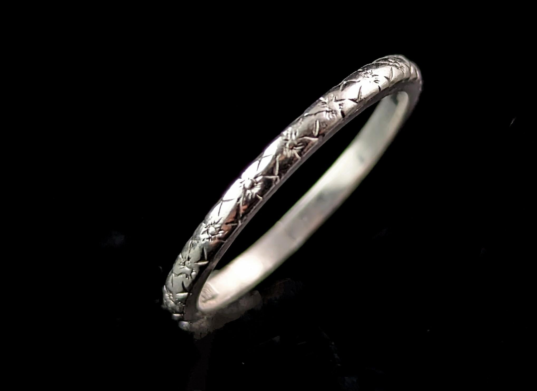 A pretty vintage Art Deco era platinum wedding band.

It is a dainty band with a pretty orange blossom engraved pattern all around the outer of the band.

It has a soft D profile and despite its dainty size it has a good weight to it.

These were