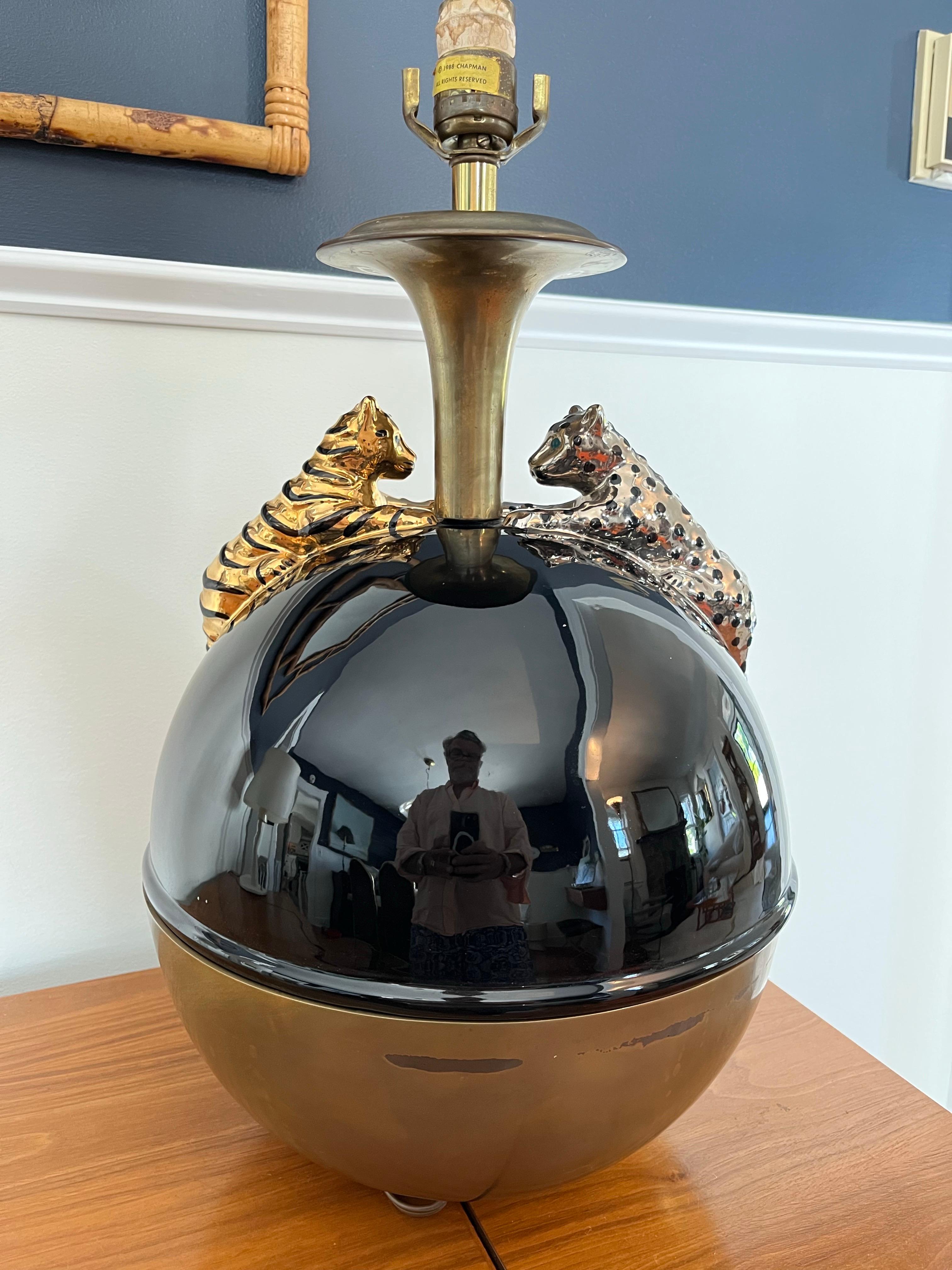 Stunning example of high style Art Deco in this porcelain and brass lamp adorned with reposed Leopard and Tiger. Heavy brass base and neck offset with jet black porcelain top. Silver Leopard and gold Tiger splay the top for a powerful visual in the
