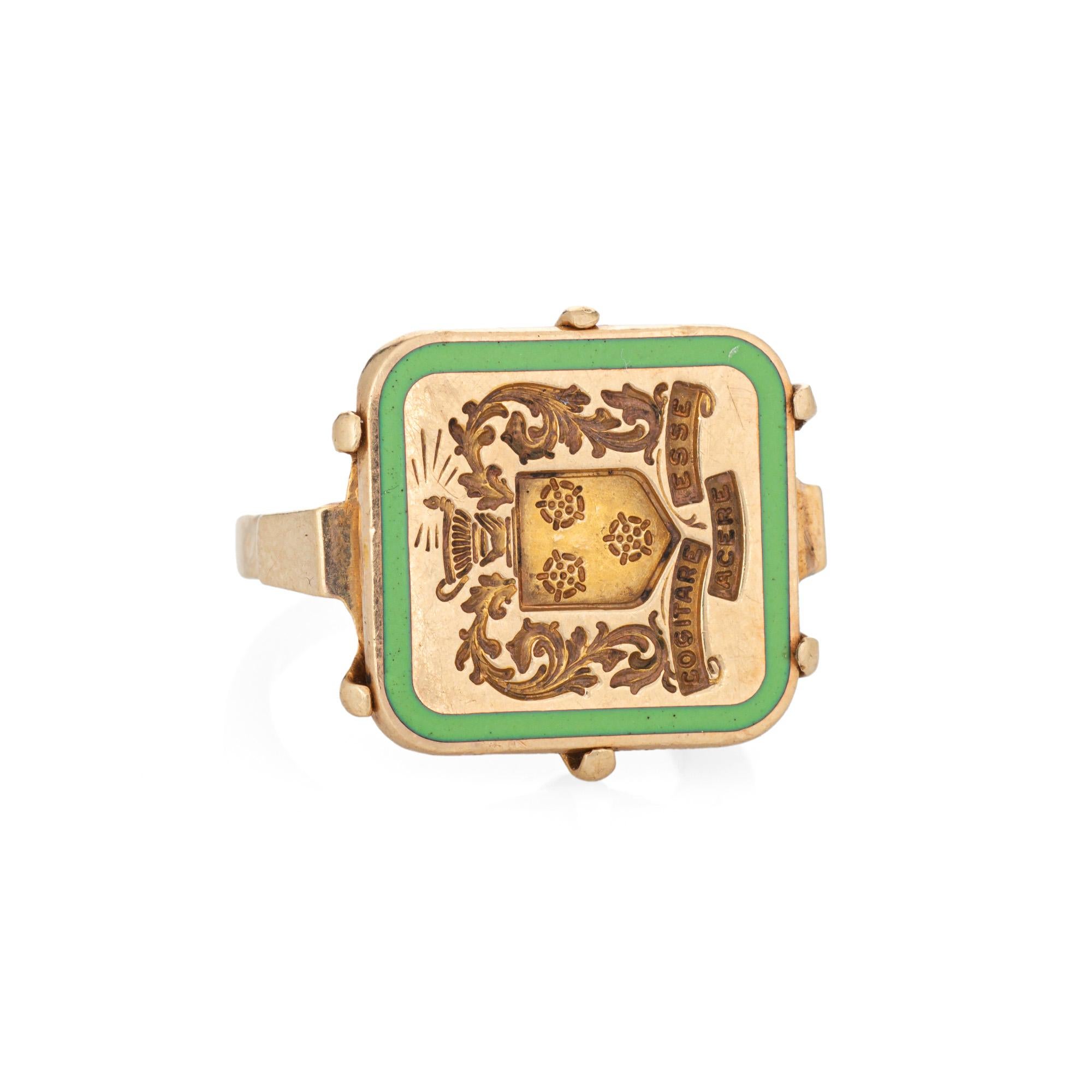 Finely detailed vintage Art Deco era family crest signet ring (circa 1920s to 1930s) crafted in 14 karat yellow gold. 

The elaborate signet mount, framed with green enamel, features a foliate motif with possibly an urn or decorative pot to the top