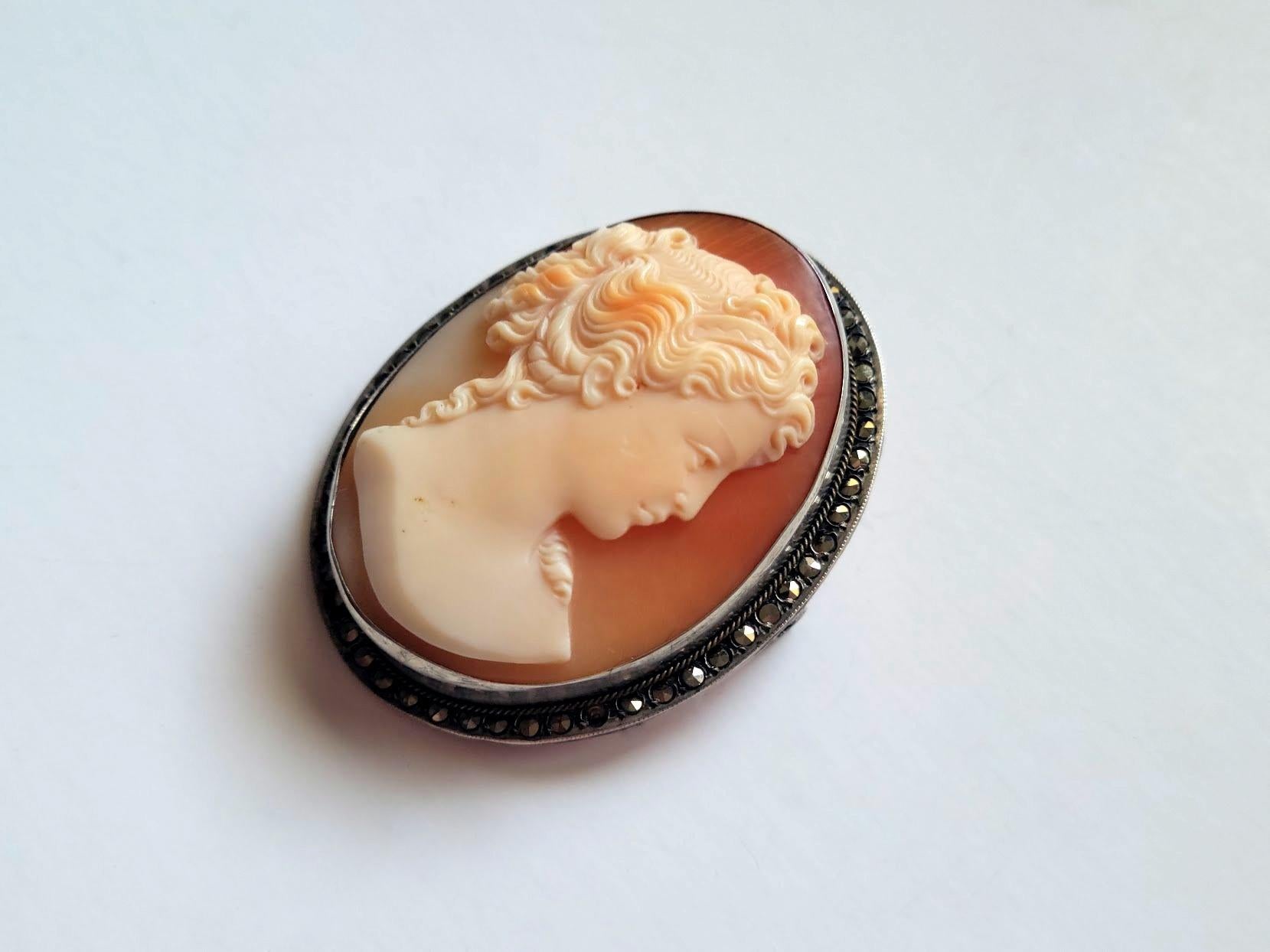 Art Deco Cameo Brooch. Fabulously carved cameo brooch made at the beginning of the 20th century, during the Art Deco era (1920-1940). It depicts a beautiful portrait of a young lady. The execution of the shell is amazing, and the relief helps to add