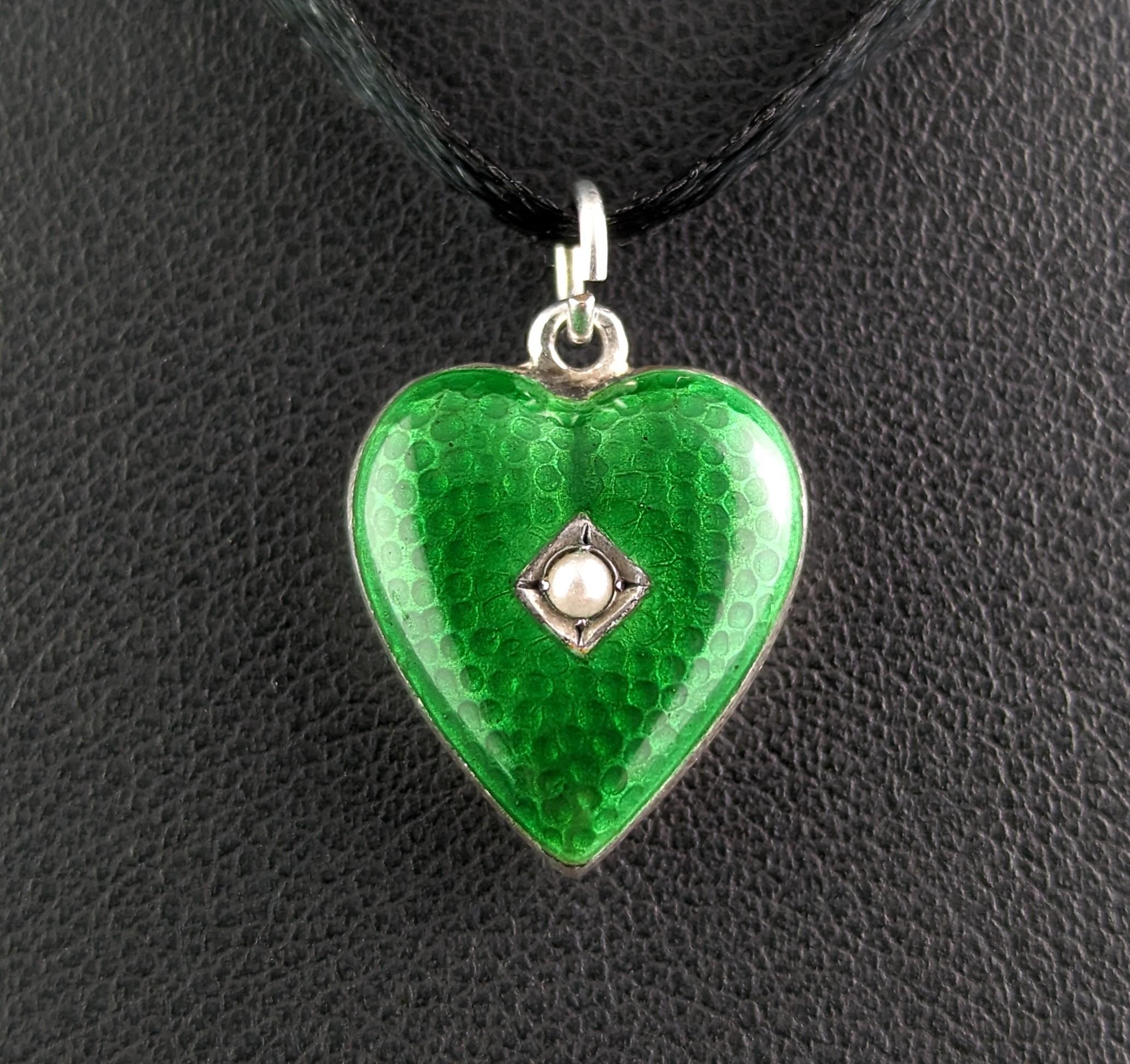 Isn't this just the sweetest ever little heart pendant!

Art Deco era, c1920s this dainty little heart pendant is made from sterling silver, the front decorated Ina rich emerald green enamel and set with a tiny seed pearl.

Such a well designed and