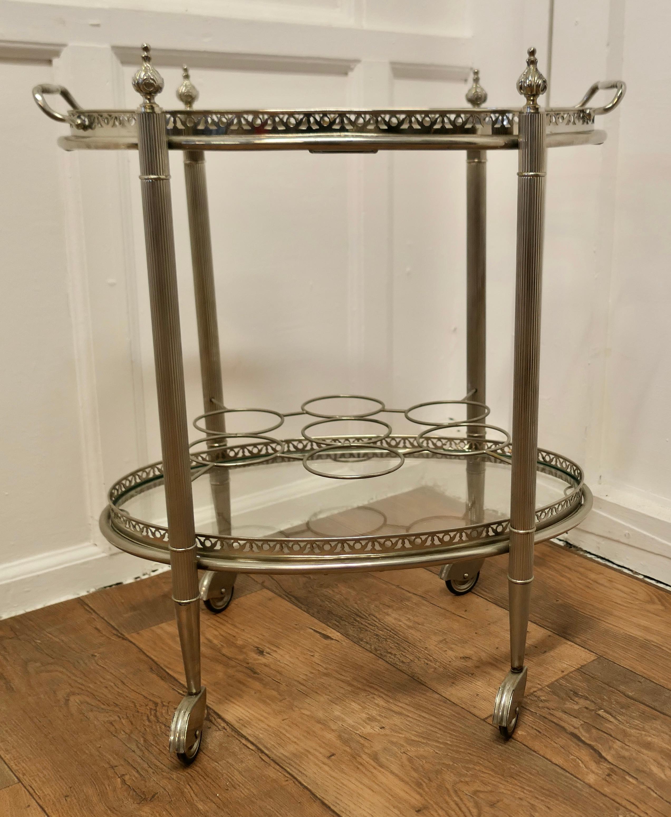Vintage Art Deco Silver Drinks Trolley with Glass Tray
A Very Decorative piece with two tiers of glass, the top one is a tray which lifts off for a serving tray, the lower shelf has 7 bottle holders and at the bottom the trolly has silver hooded