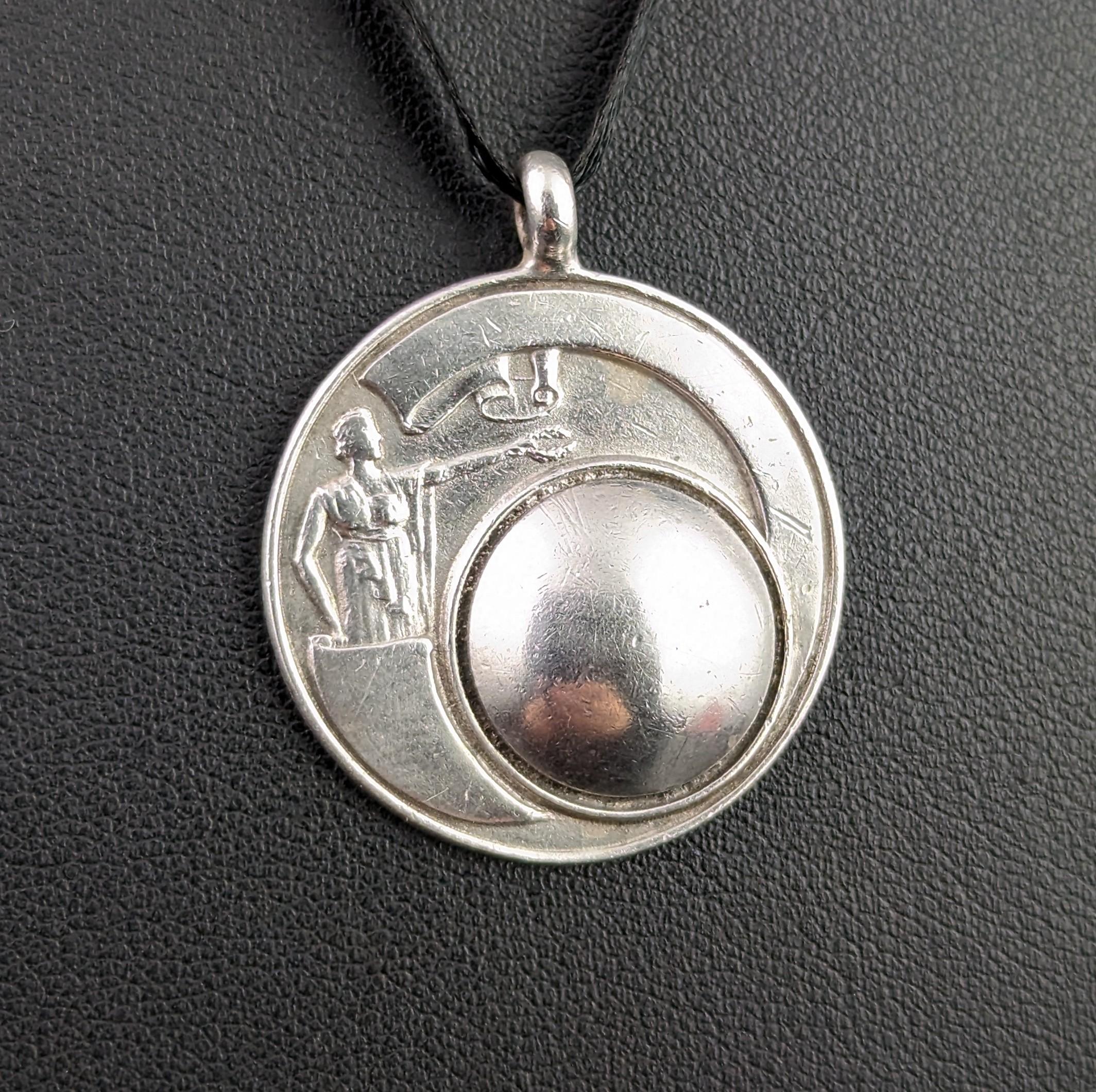 An attractive and unusual vintage, early 1930's sterling silver fob pendant.

A nice decorative fob it features a figure holding out a laurel wreath crown above a large domed section, it has an almost space age feel to it.

It has an integral silver