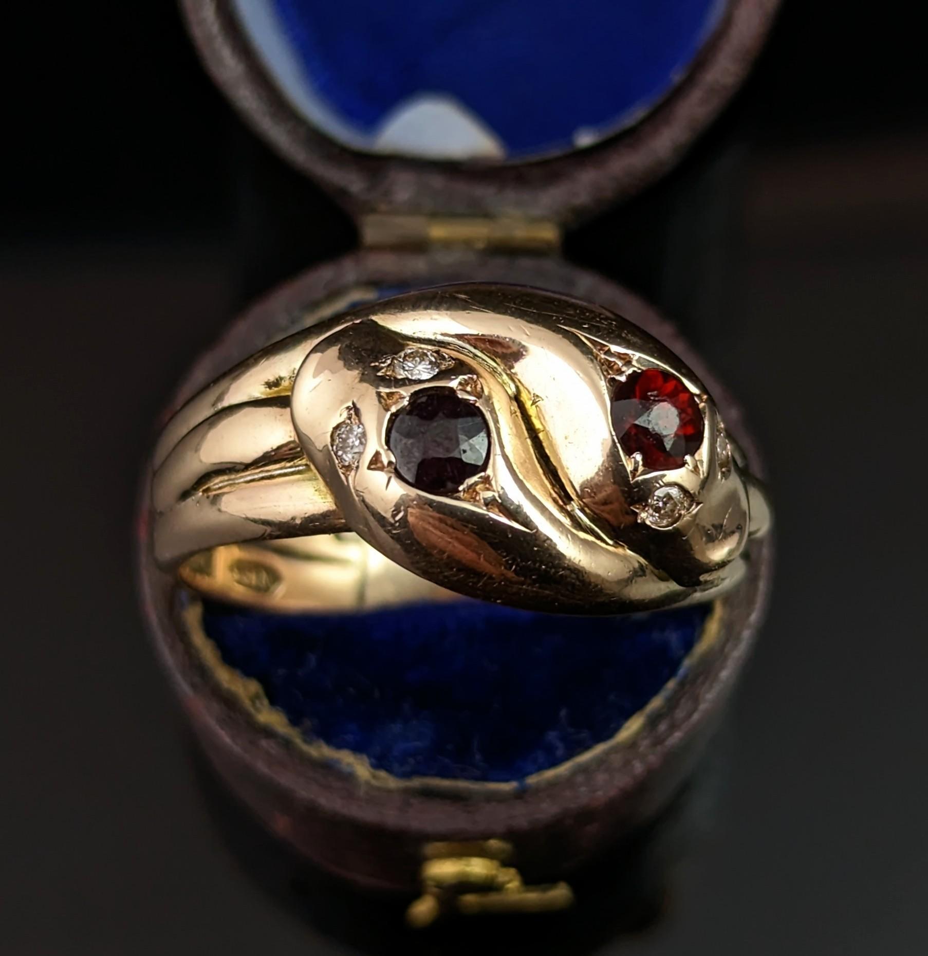 Be enchanted by this handsome Vintage, Art Deco era garnet and diamond double snake ring.

Coils of rich yellow gold form the body of these handsome intertwined snake pals, the heads are modelled as the face of the ring with the snakes both having