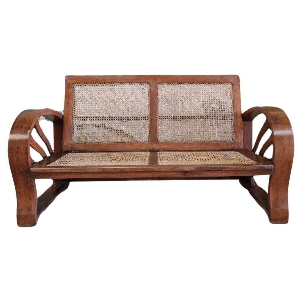 
This vintage Art Deco sofa from the 1930s exudes elegance and sophistication. Made of high-quality walnut wood and adorned with intricate cane seat and backrest, this two-seater sofa is perfect for anyone who loves vintage furniture. With its rich