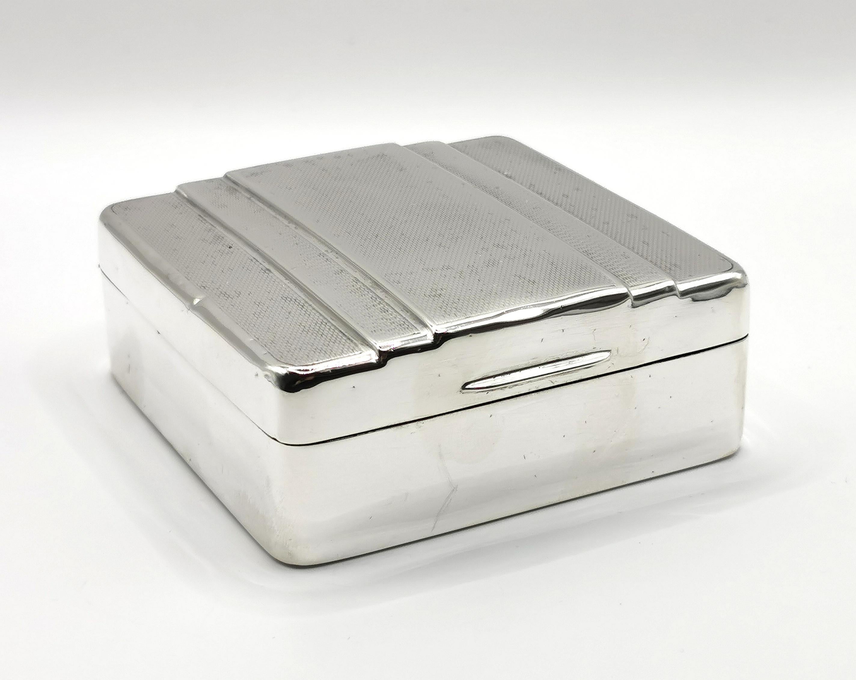 A stylish vintage Art Deco era sterling silver cigarette box.

This is a single sized box, with storage for multiple standard sized cigarettes.

The box has is engine turned to the lid with a stepped design.

The body of the box has a smooth