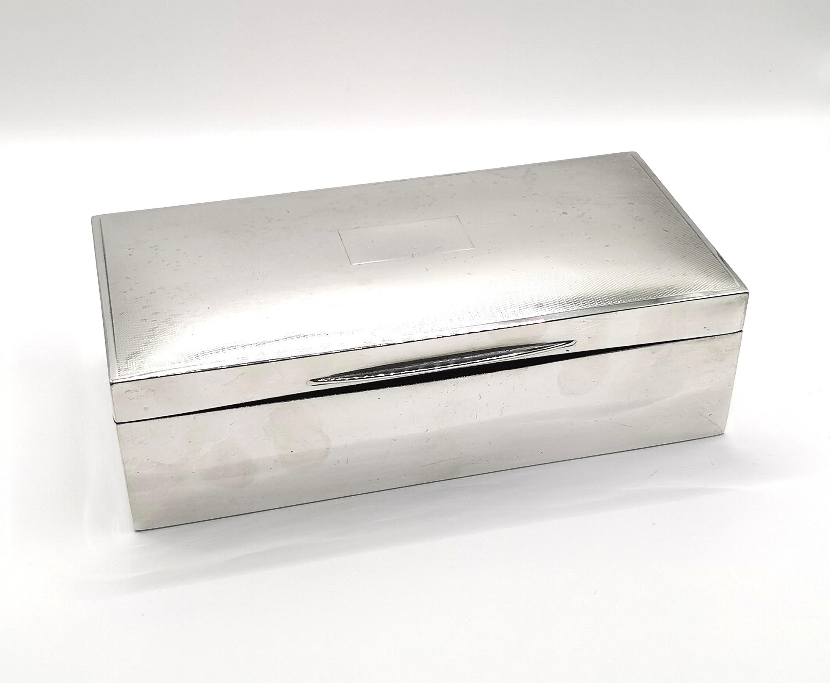 A stylish vintage Art Deco era sterling silver cigarette box.

This is a large sized box, substantial and heavy, it could also be used as a cigar box.

The box has an engine turned design to the lid with a blank cartouche, thix could be