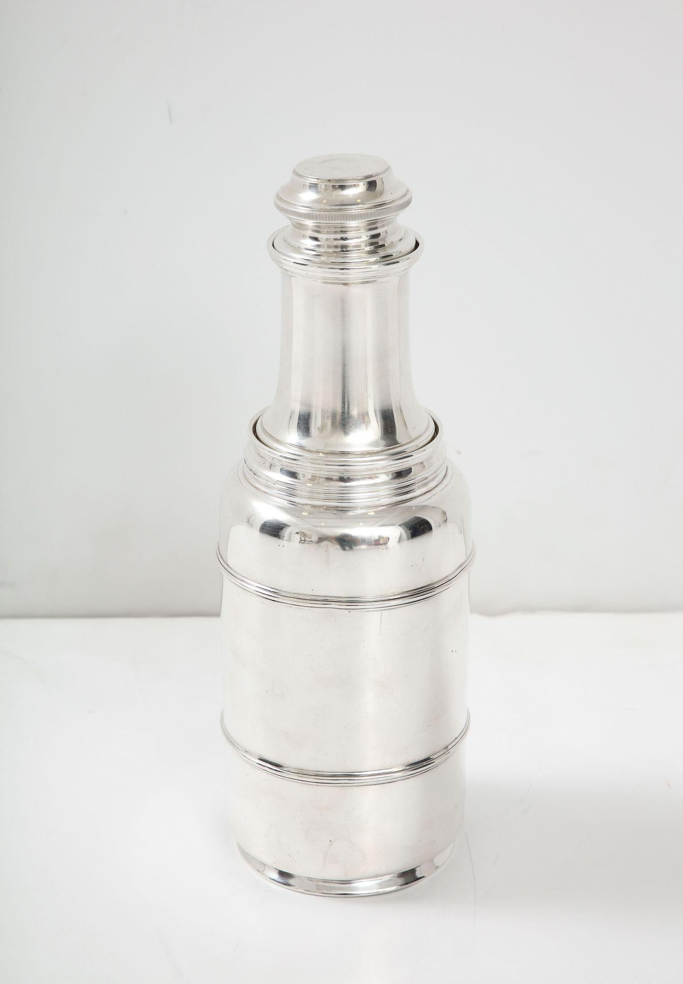 A great rare Art Deco cocktail shaker in sterling silver with a juicer and measuring cup.  There is a silver mark by Lebkuecher of Newark
