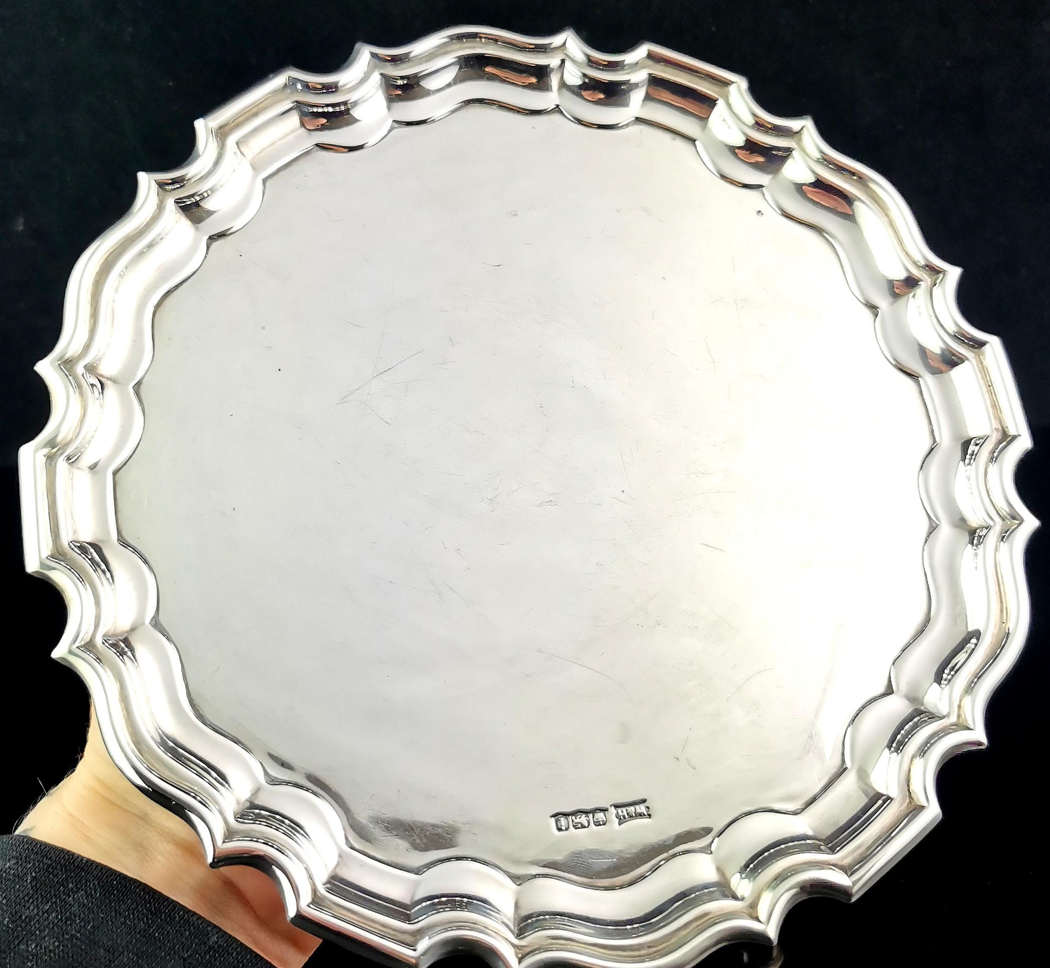 An attractive vintage Art Deco era sterling silver salver.

It has an attractive scalloped double rim edge and stands on volute feet.

A handsome and well made salver by a renowned maker, Walker and Hall.

The tray has elements of Art Deco design