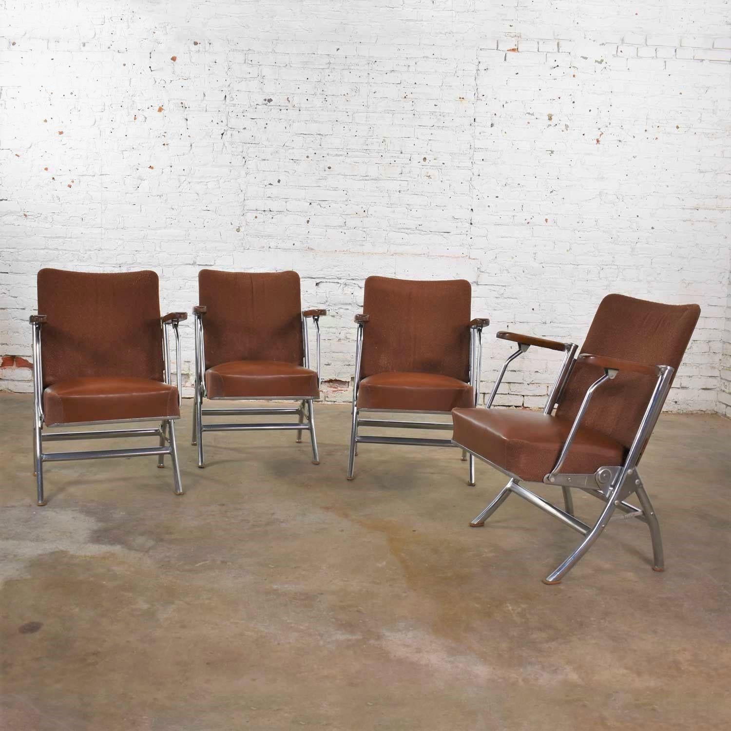 Twenty-nine handsome folding auditorium chairs or theatre seats. They are in an Art Deco, Streamline Modern, Art Moderne, Machine Age, or Bauhaus style in chrome, frieze fabric, vinyl (faux leather), and wood. Although these are not marked, we have