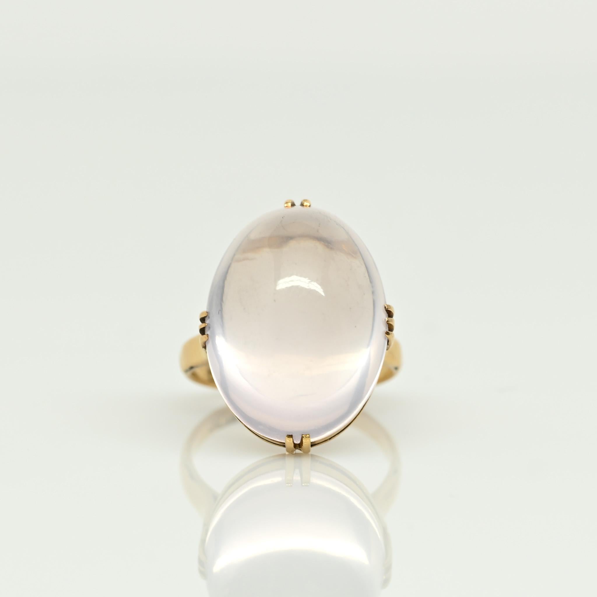 Behold this truly distinctive beauty! The central moonstone, an approximately 18.3Ct oval cabochon, showcases a stunning lavender hue that adds an extraordinary touch. Nestled in an 18K yellow gold prong setting, the gumdrop-shaped moonstone finds