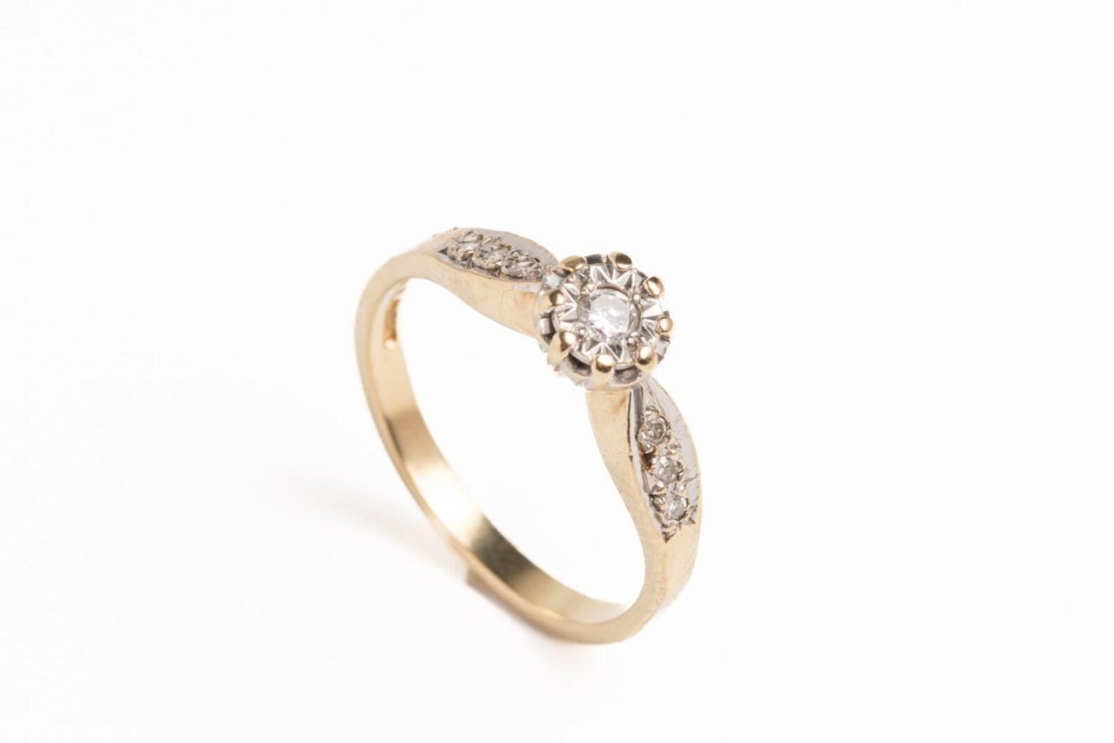 A Vintage 9ct yellow gold diamond solitaire ring with a central diamond in claw setting and shoulders decorated with six small diamonds ( three on each shoulder). The ring is boxed and carries hallmarks for Sheffield along with the '375' 9ct gold
