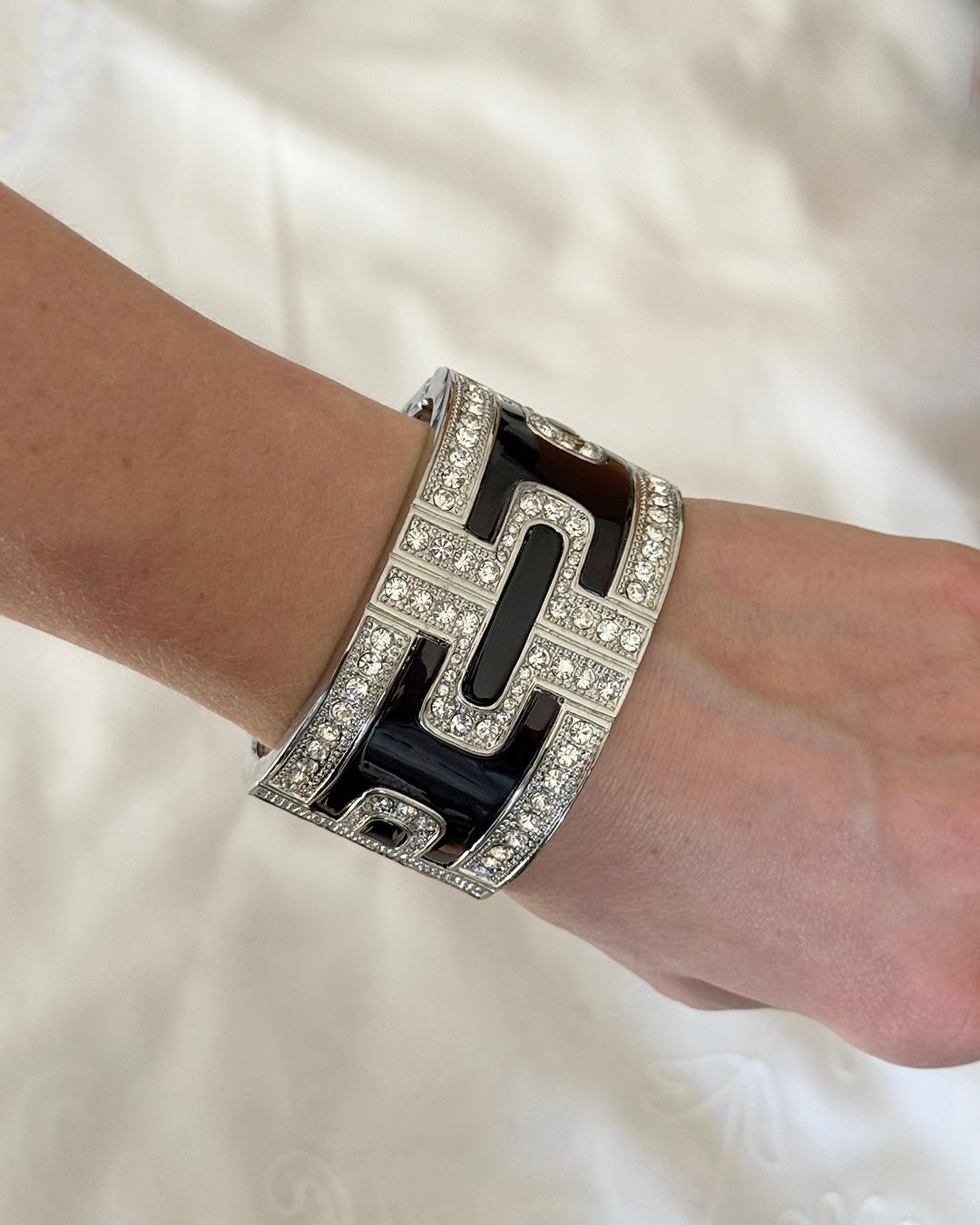 Questo braccialetto vintage in smalto nero Art Deco emula i braccialetti di tendenza degli anni Trenta. Un pezzo sostanzioso, caratterizzato da un intarsio di smalto nero in forma geometrica, compensato da cristalli e texture millegradi. Non è