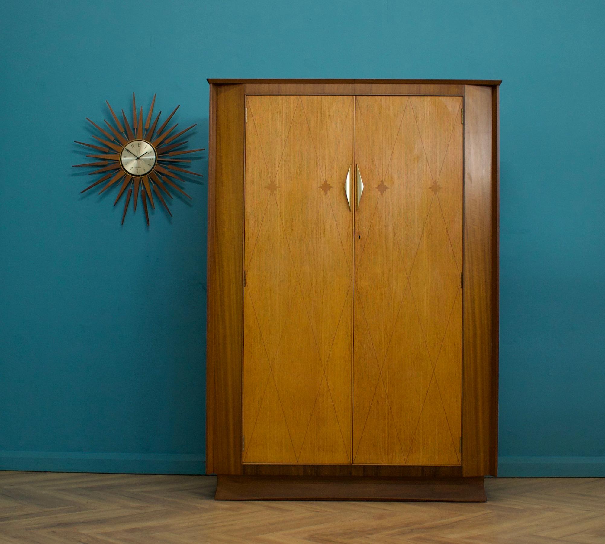 A mid century walnut and oak Art Deco style wardrobe from Harris Lebus - circa 1950's


This piece has beautiful inlays to the doors
Featuring brass handles 


Inside is fitted out with two clothes rails and a shelf 


The matching dressing table