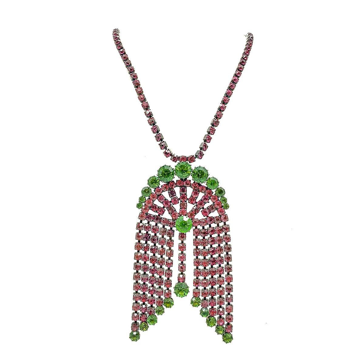 A Vintage Crystal Tassel Necklace. Featuring a stunning, contrasting combination of pink and green crystals, each individually set within an Art Deco inspired arched tassel design.  The impressive pendant suspended from an end to end chain, or