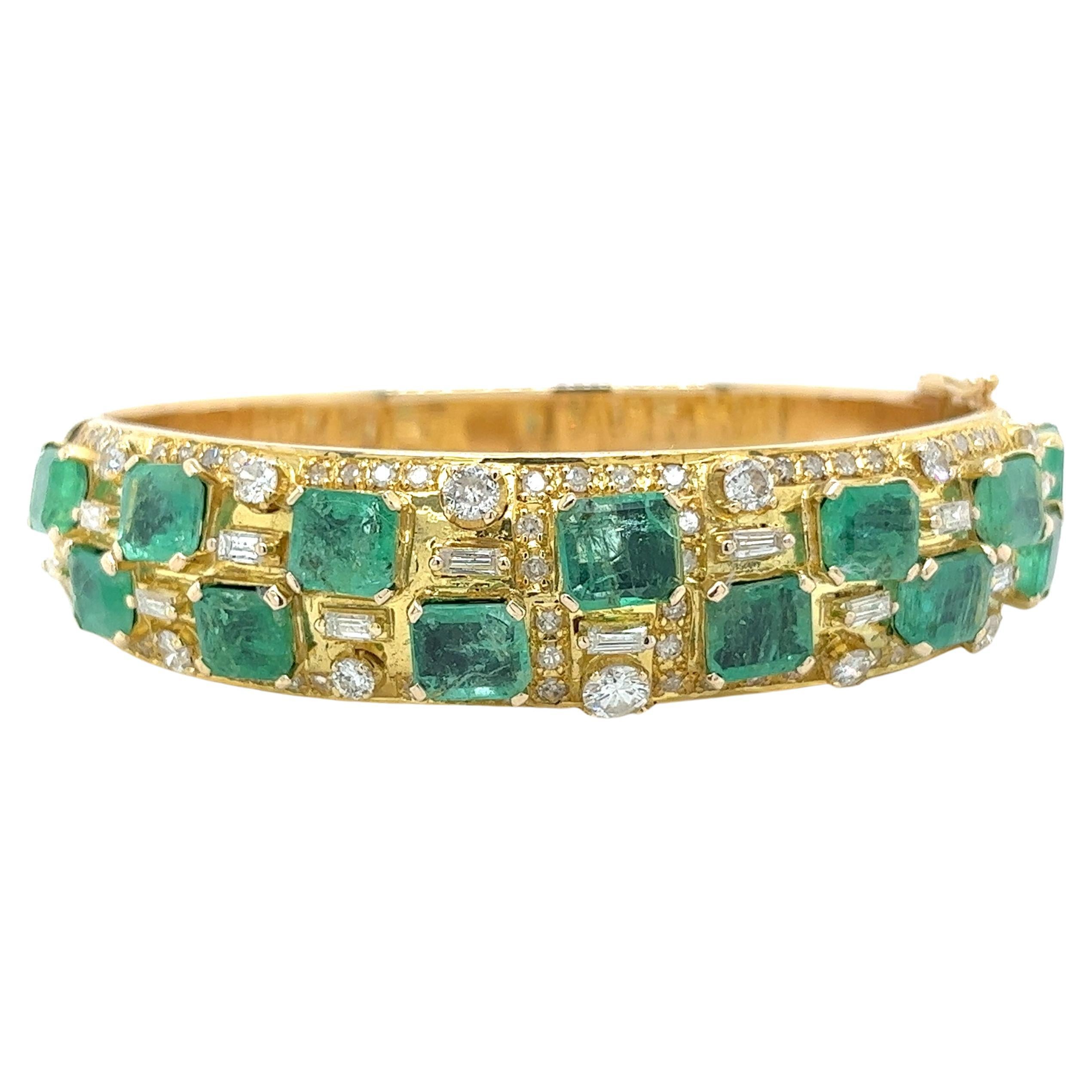 Vintage, art deco-inspired natural emerald and diamond bangle bracelet in 18 karat yellow gold. Featuring 13 square emerald cut emeralds of 13 carats total, with a stunning assortment of varying-sized round and baguette-cut diamonds.