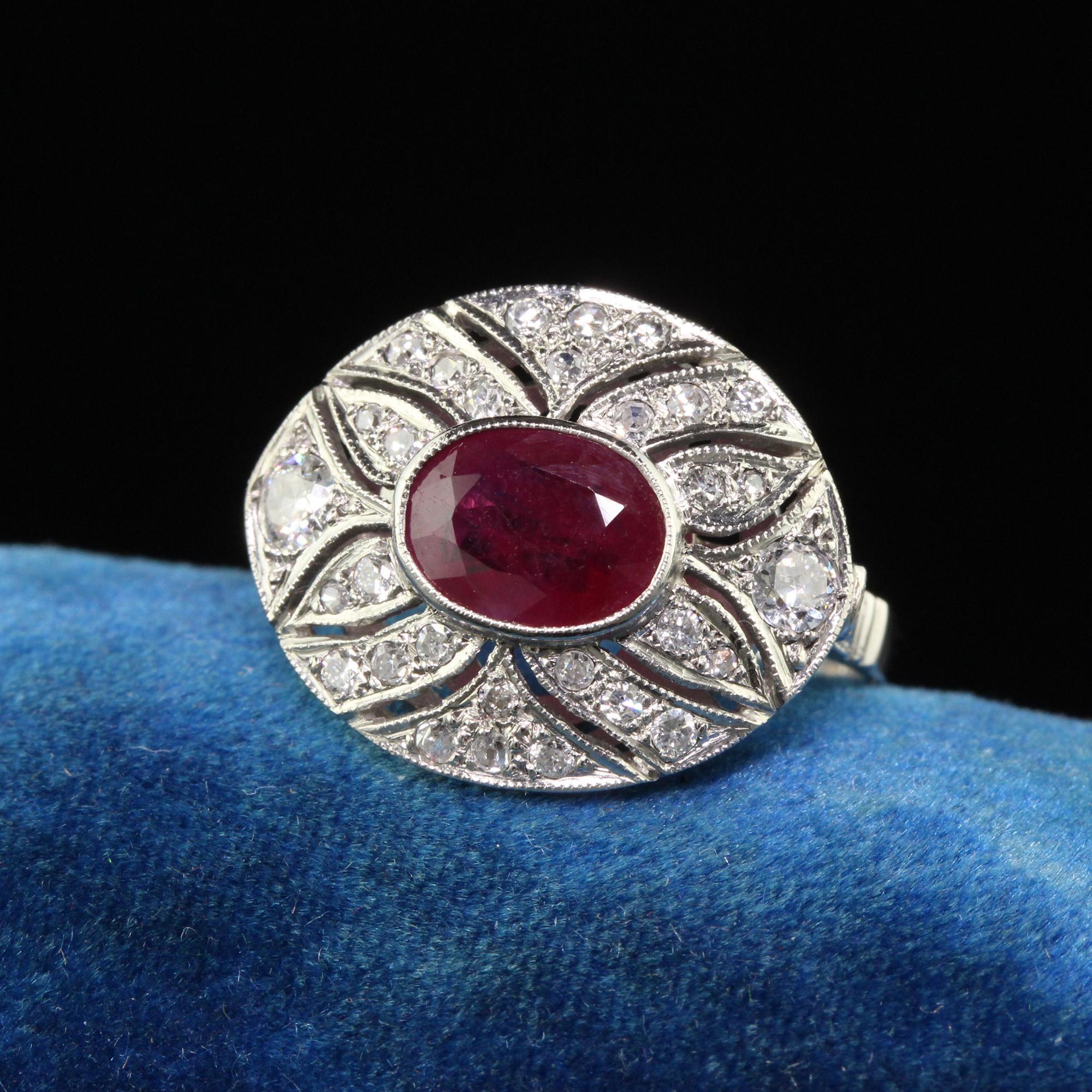 Beautiful Contemporary Art Deco Style Platinum Ruby and Diamond Cocktail Ring. This beautiful ring is crafted of platinum. The center holds a natural red ruby and is surrounded by white single cut diamonds. The craftsmanship is beautiful and very
