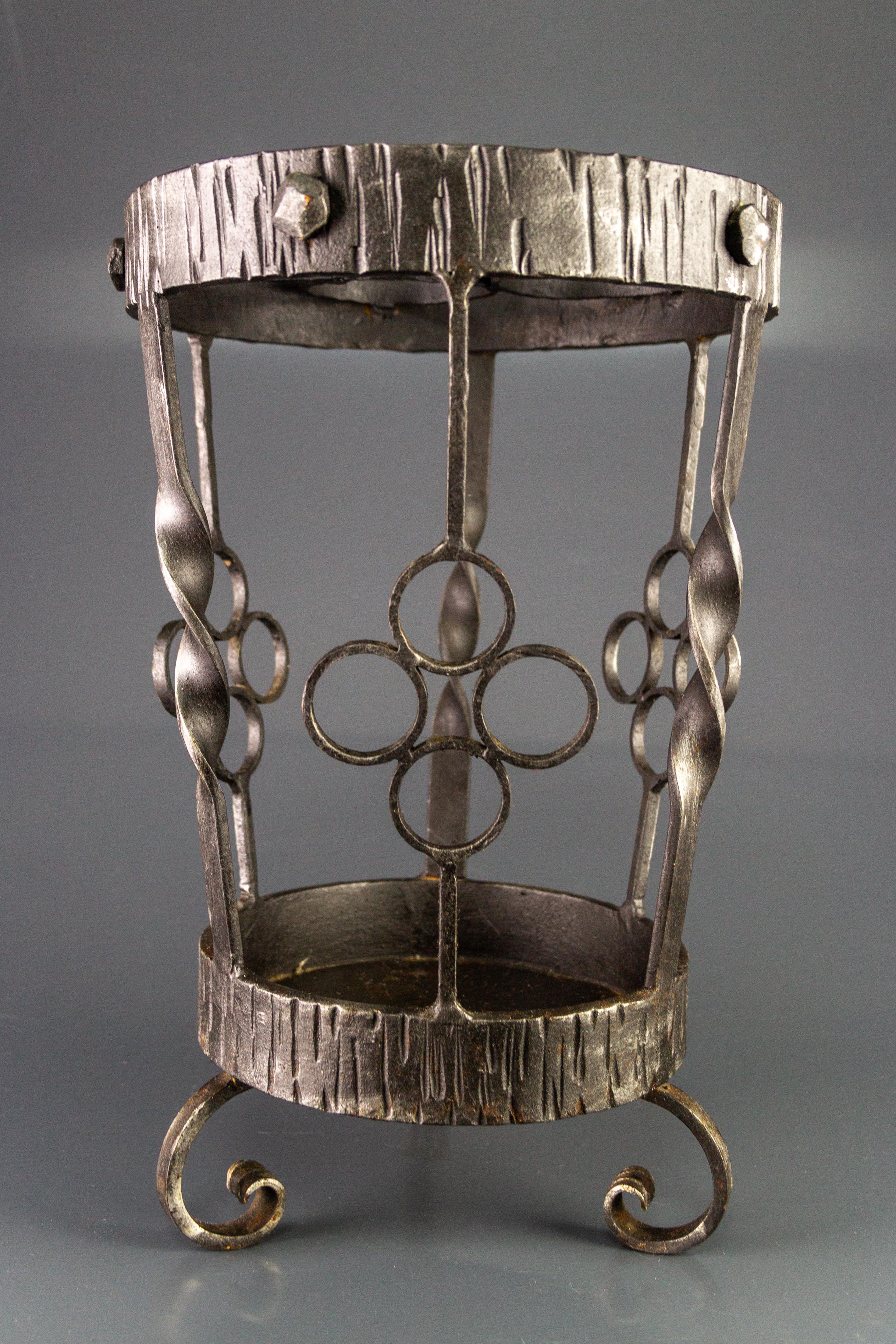 Vintage Art Deco style hand-wrought iron umbrella stand that can be used also as a cane holder. Germany, 1950s.
Dimensions: height: 40 cm / 15.74 in; diameter: 26 cm / 10.23 in.