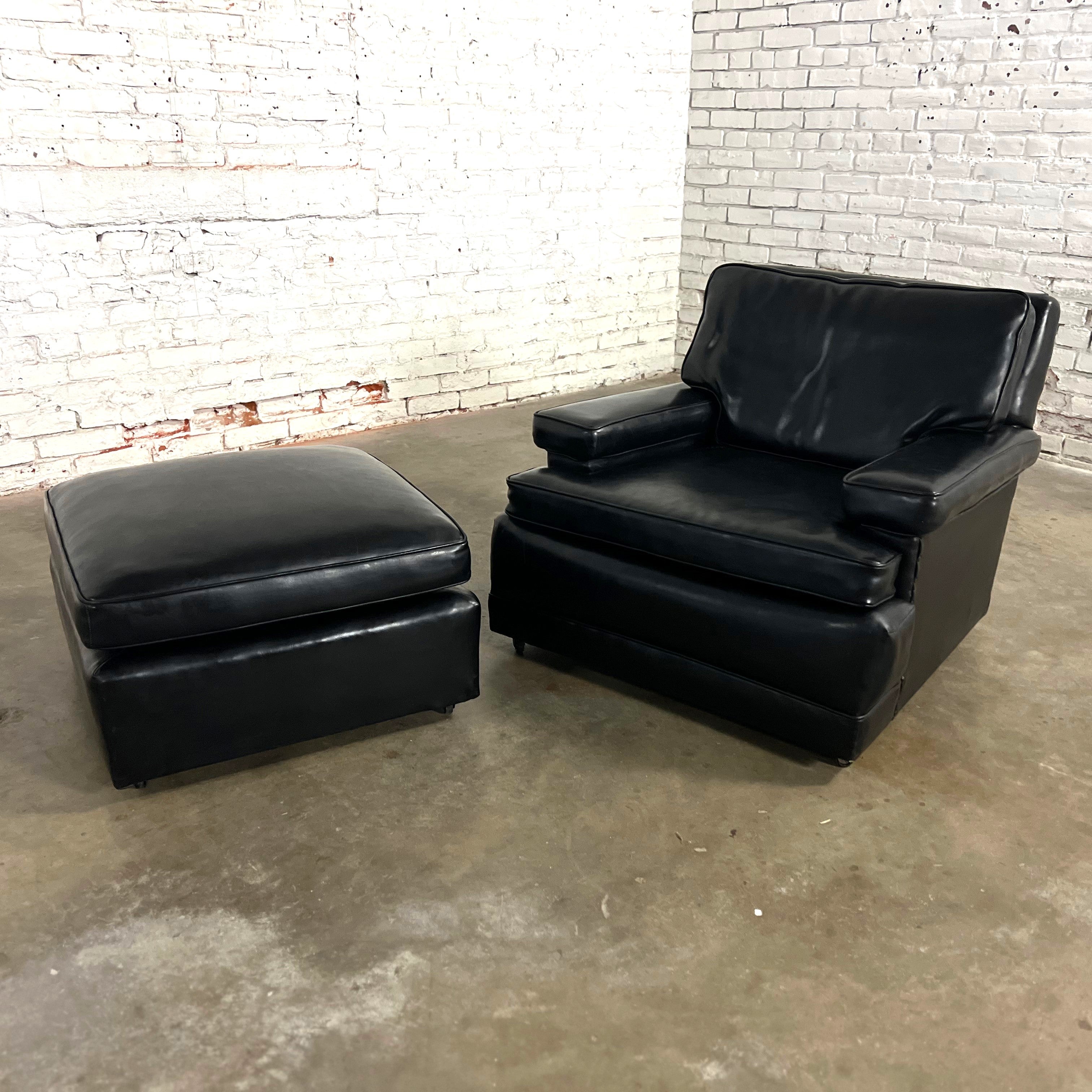 Fantastic Mid-20th Century Art Deco to Mid Century Modern black faux leather club chair & ottoman. The chair has black nail head detail, a loose seat & back T-cushion, front casters, and blonde wood block style back feet. Ottoman has a semi attached
