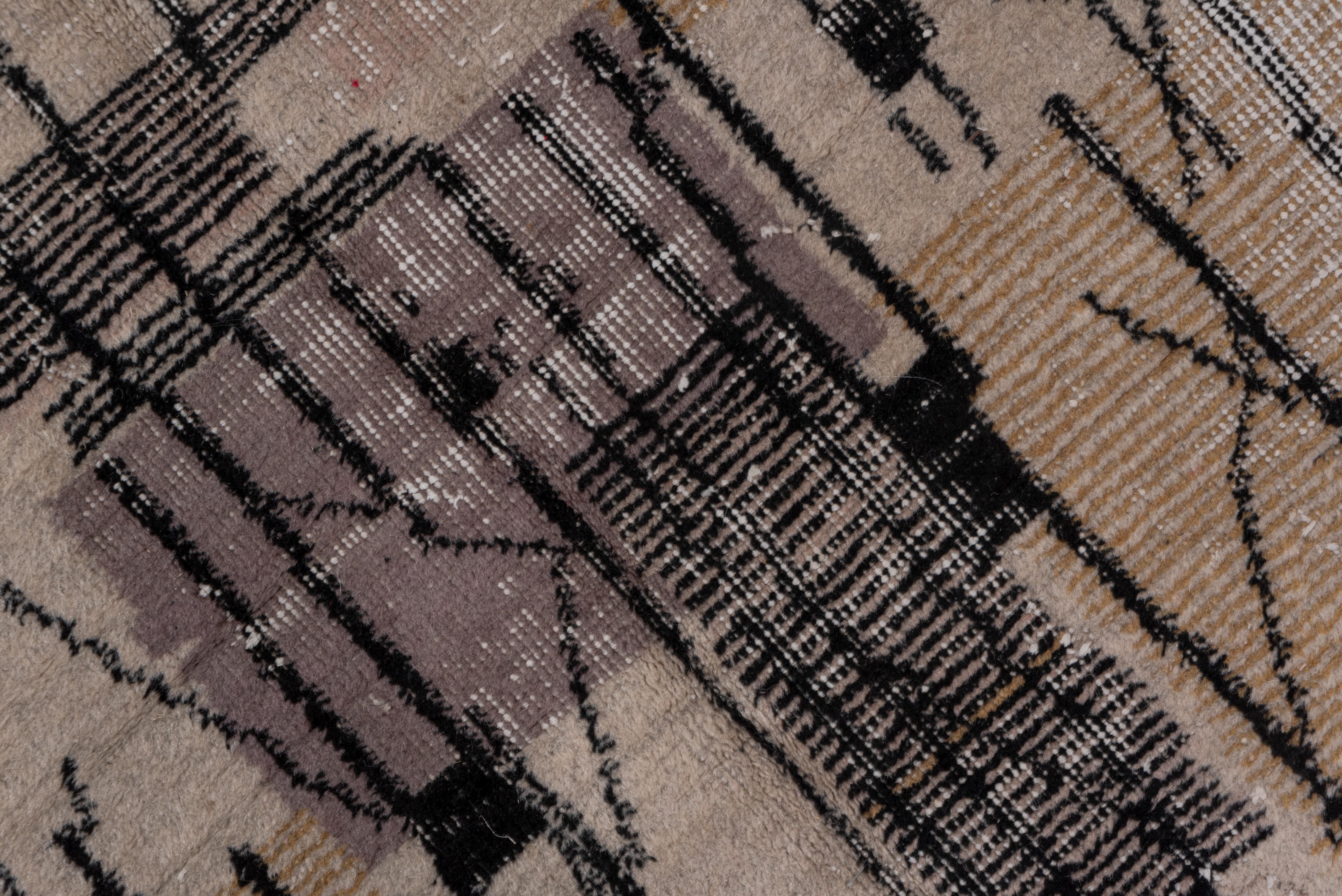 This irregularly good pile to distressed borderless carpet was woven with a repeating, abstract pattern of rectangles, close parallel lines, and longer, freely floating verticals in shades of grey flannel, black, and cream. The pattern relates to