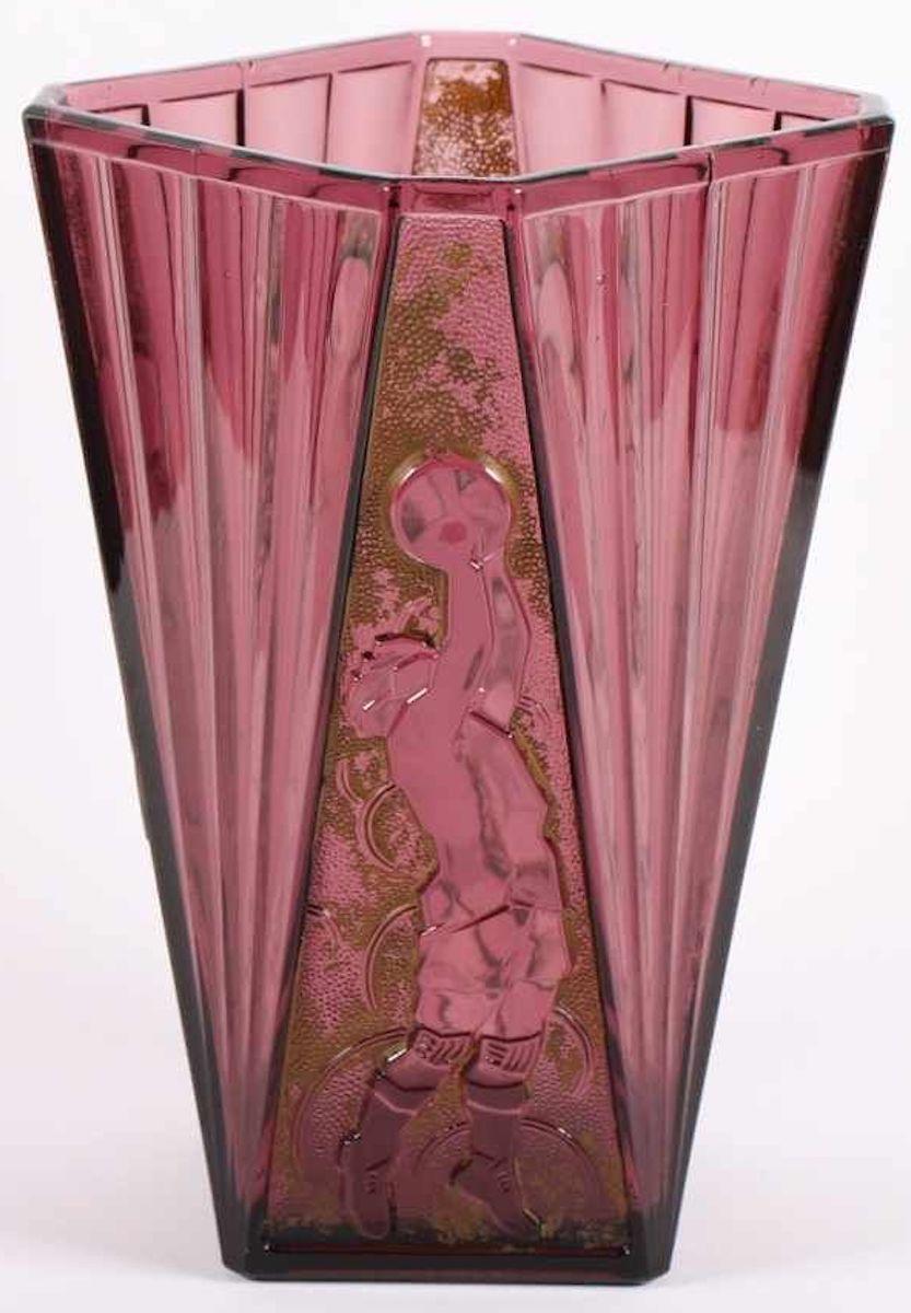 Dies ist eine wunderschöne Art Deco Vase, die um 1930 in Belgien hergestellt wurde.

Mauvefarbenes Glaskunstwerk mit einem erhabenen Kugelmotiv und einem Basketballspieler als Dekoration auf teilweise goldpatiniertem Hintergrund.

Auf dem Sockel